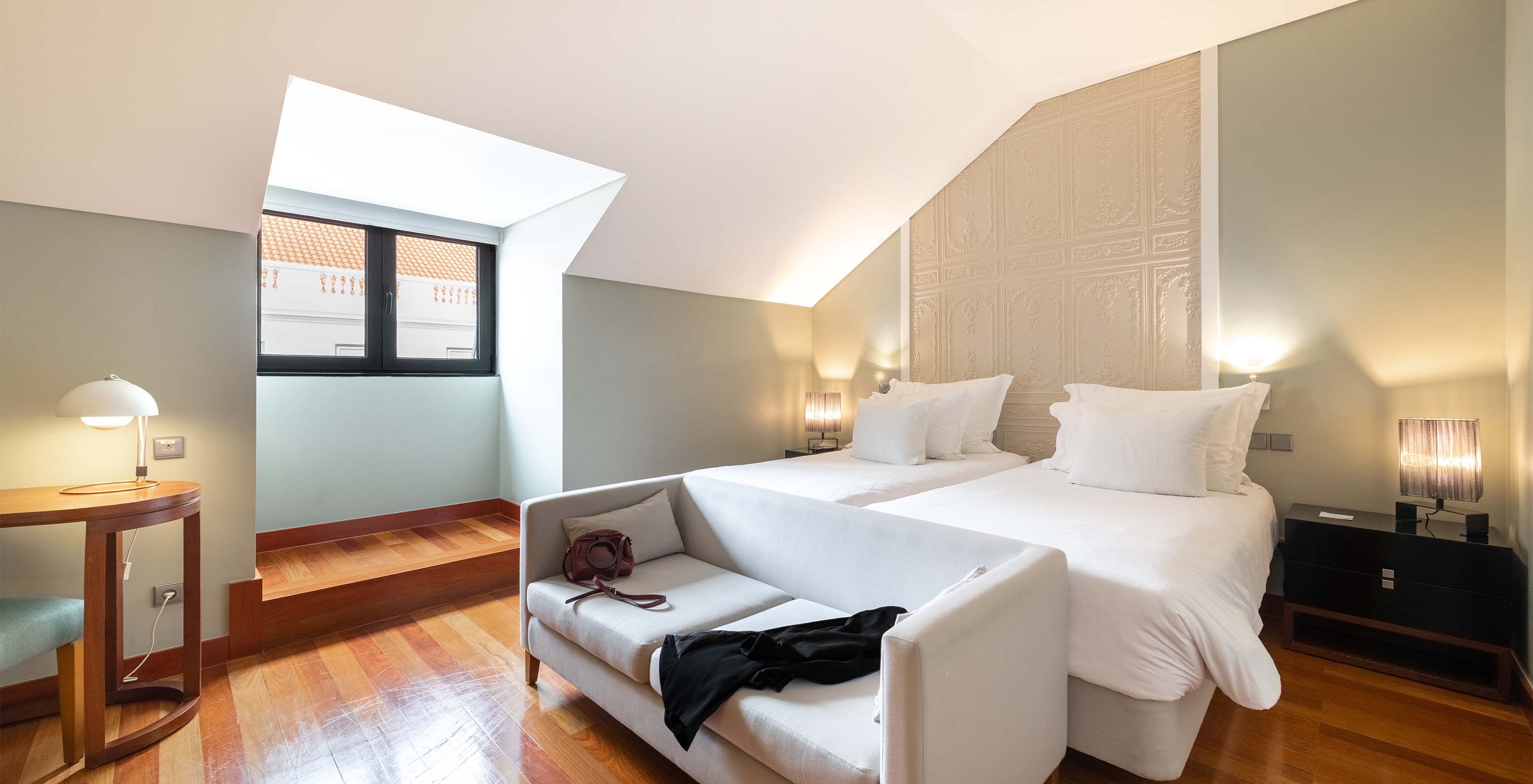 The Superior King Size Bed of The Pousada Lisboa Praça do Comércio has two single beds with a sofa at the foot and a window