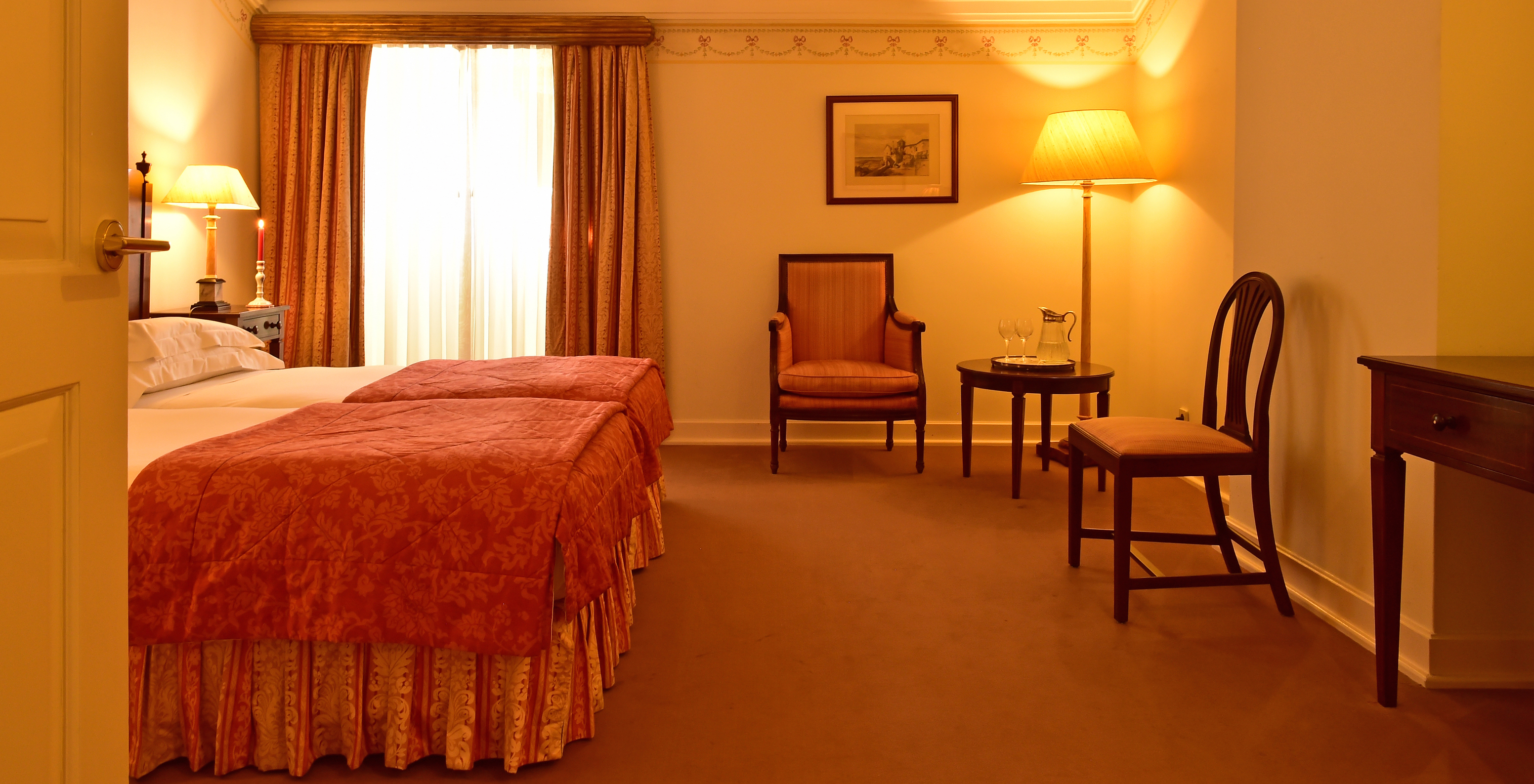 The Classic Room of The Pousada Palácio Queluz features ample space around the bed, with two chairs and a window