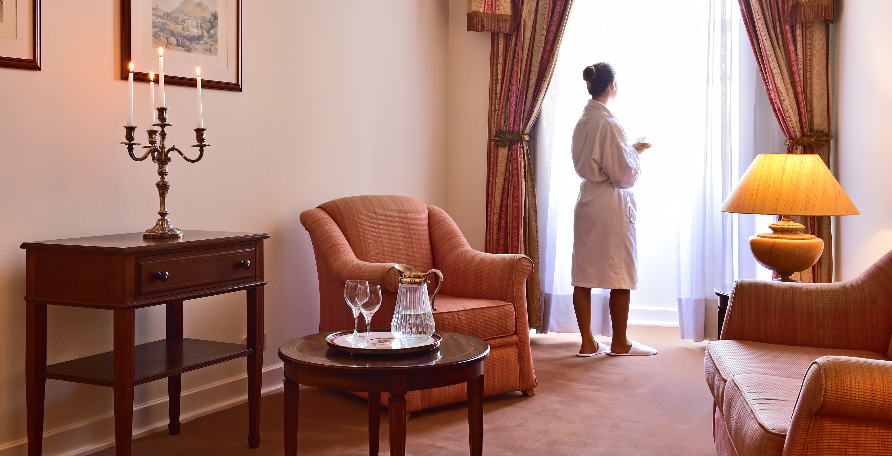 In The Standard Suite of The Pousada Palácio Queluz, you can enjoy the living room with an armchair and a side table