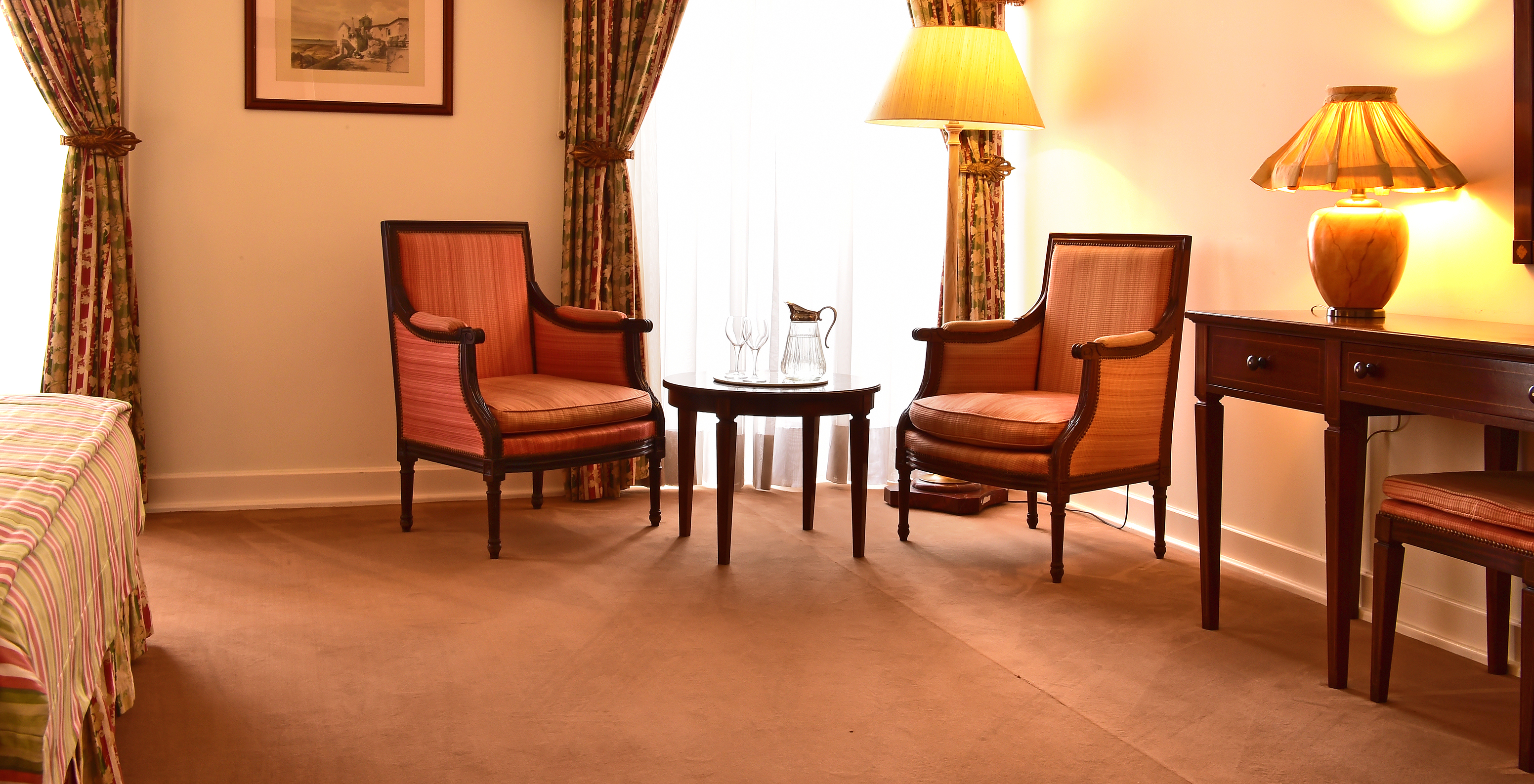 The Superior Room of The Pousada Palácio Queluz features a seating area with two sofas, a coffee table, and windows