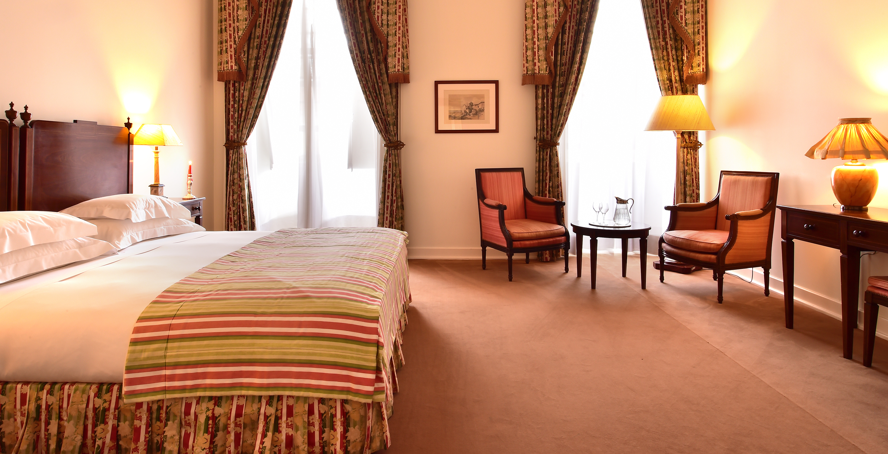 The Superior Room of The Pousada Palácio Queluz has ample space with two single beds, a sofa, and two chairs