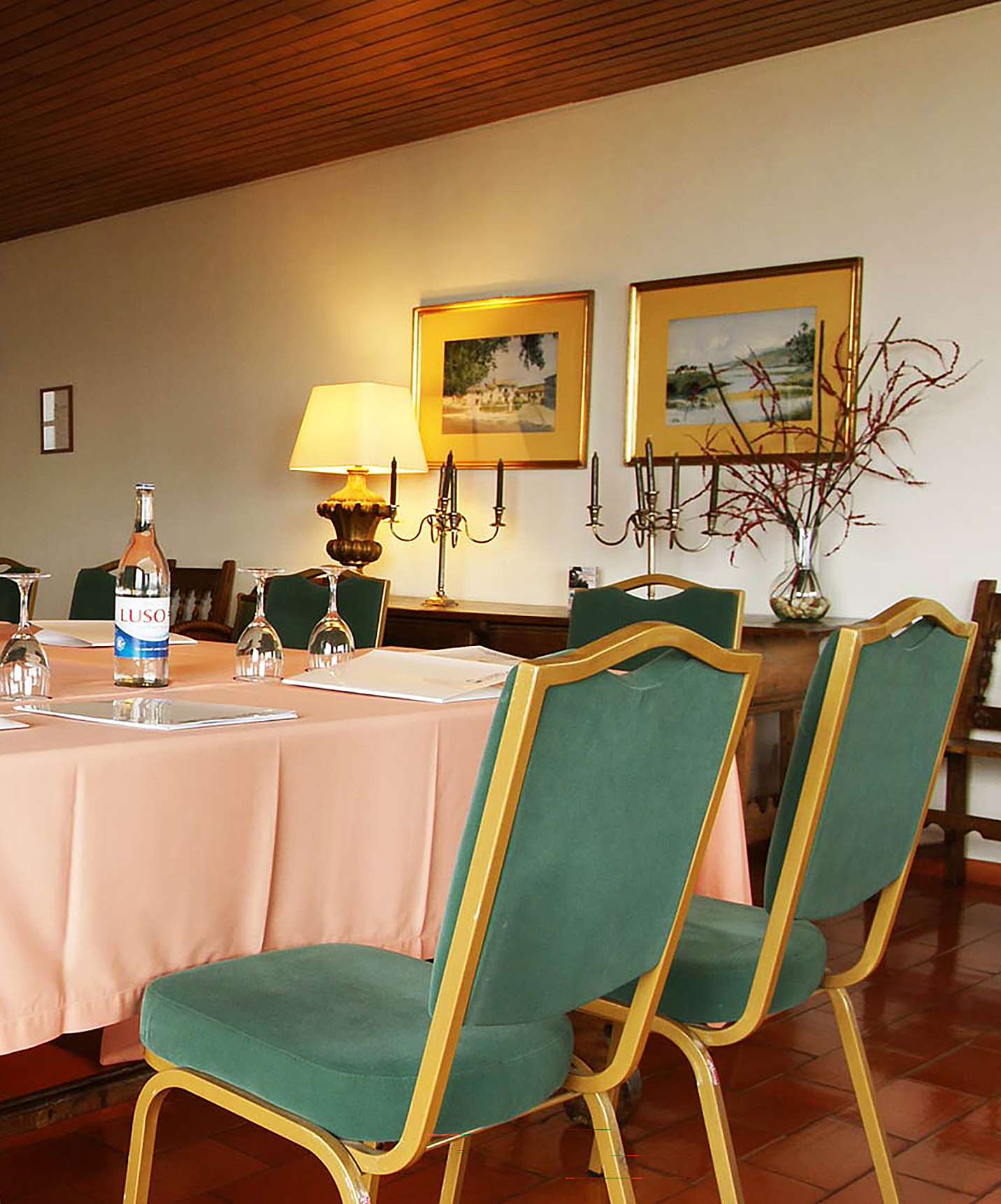 Pousada Valença, a Charming Hotel in Valença, has a meeting room with green chairs and a table with water