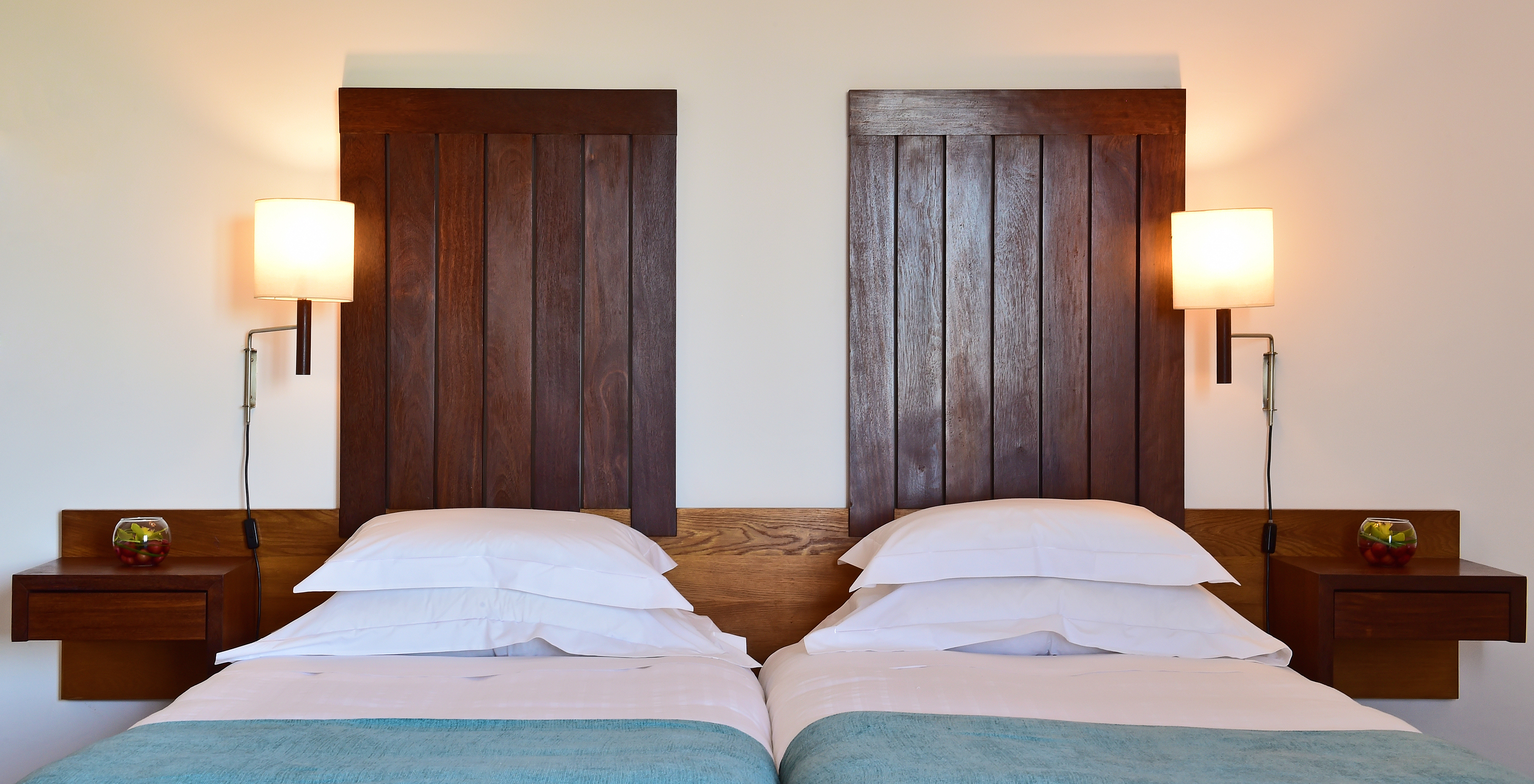 The Large Family Room of the Pousada Castelo Alcácer do Sal has two separate beds, with a blue blanket and a wooden headboard