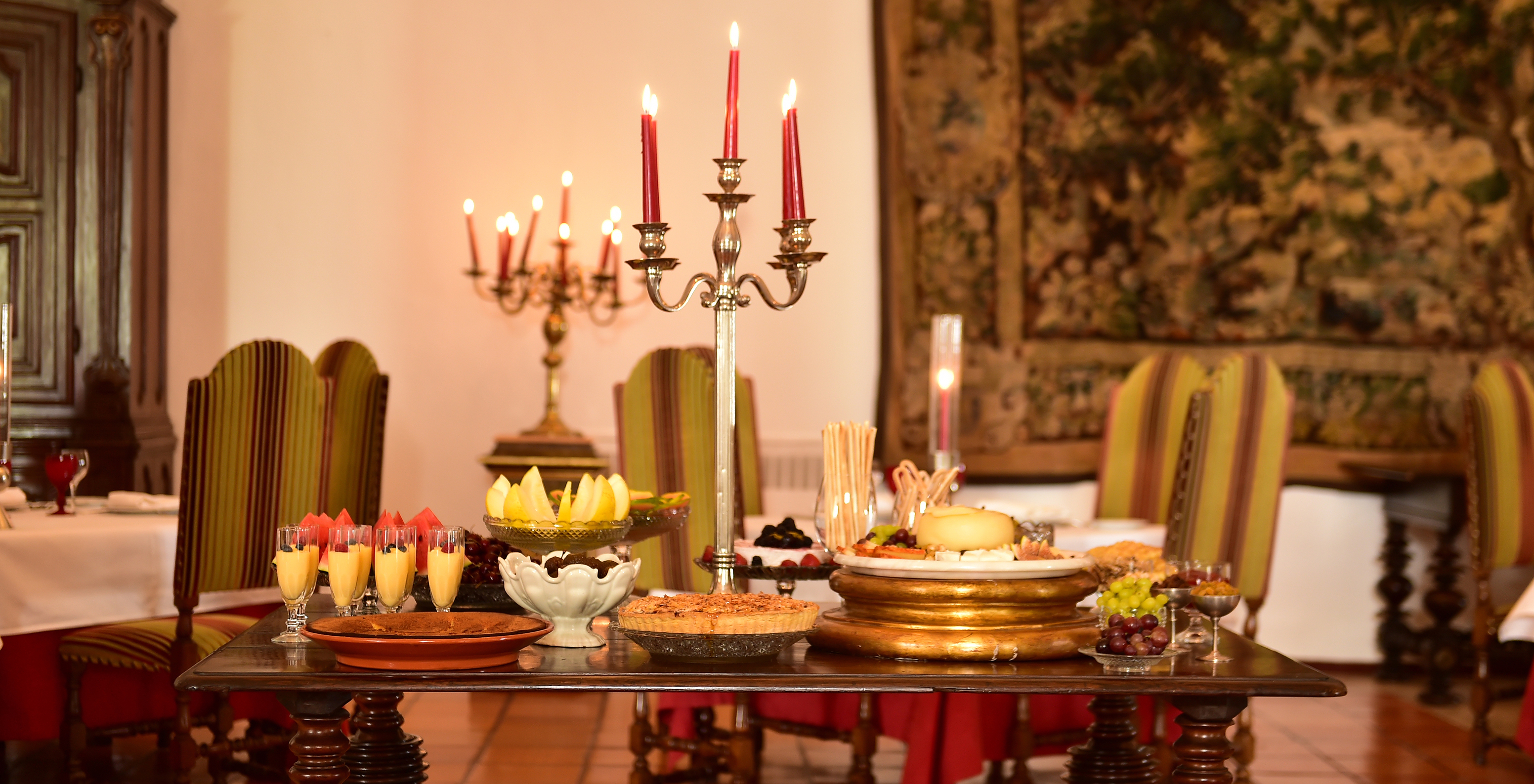 The restaurant at the Historic Hotel in Estremoz, Alentejo, has a table with desserts and a carpet decorating the wall