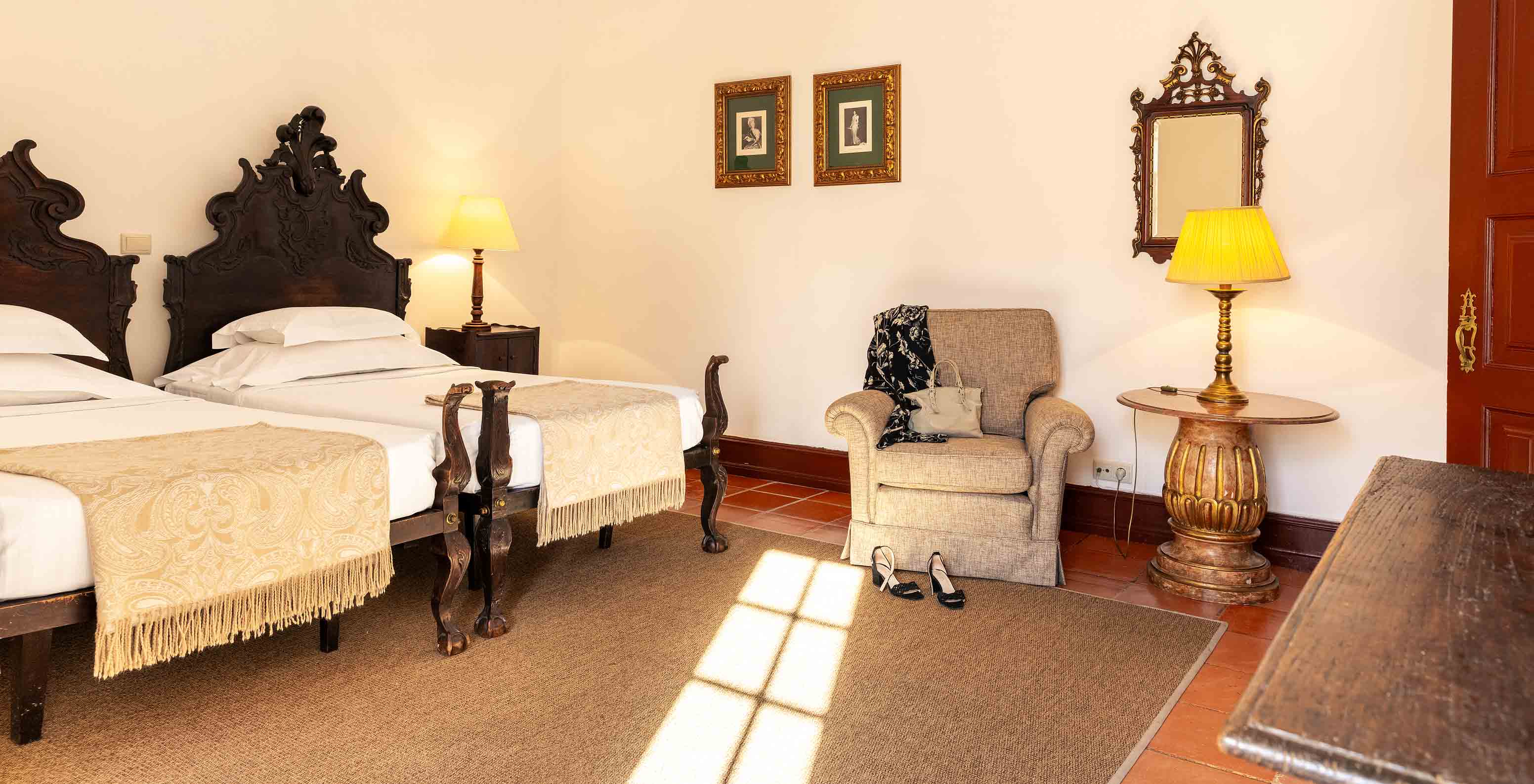 The Superior Family Room at Pousada Castelo Estremoz has two single beds in dark wood, with a yellow bedspread