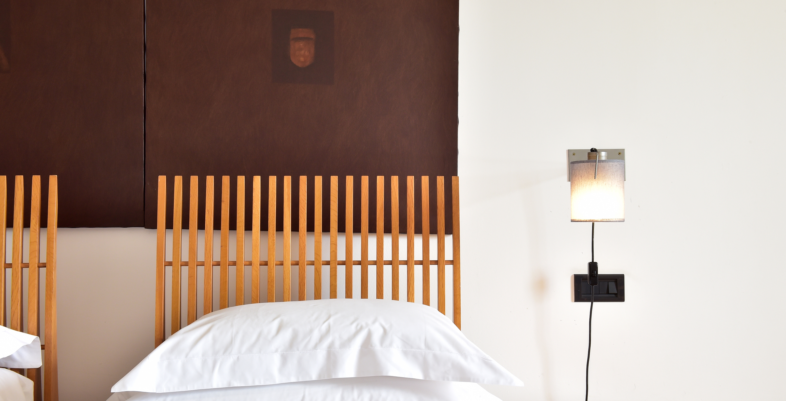 The Superior Room of The Pousada Convento Arraiolos has two single beds with white sheets and a wooden headboard