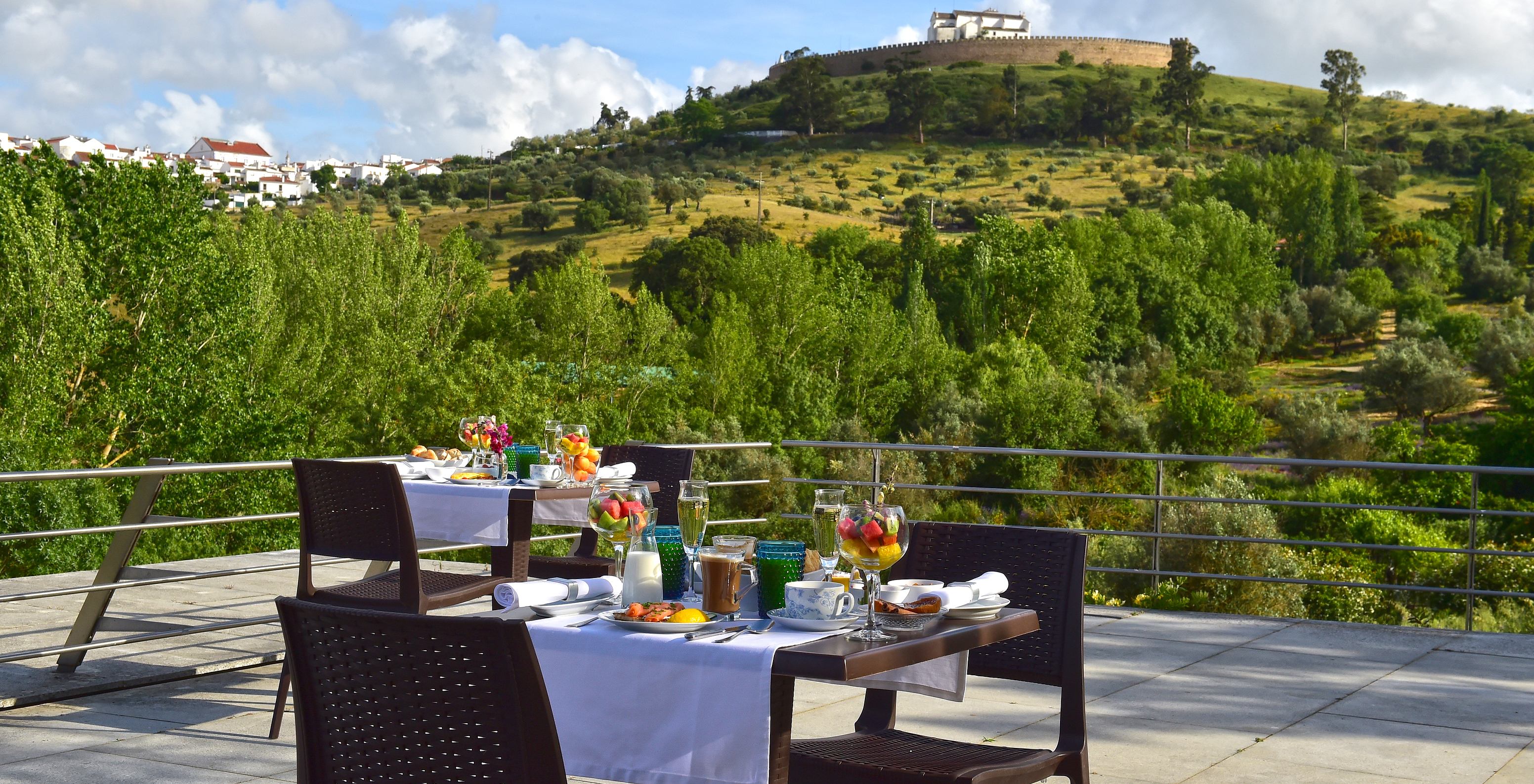 Breakfast table on the terrace with a view of the lush nature around the Pousada Convento Arraiolos