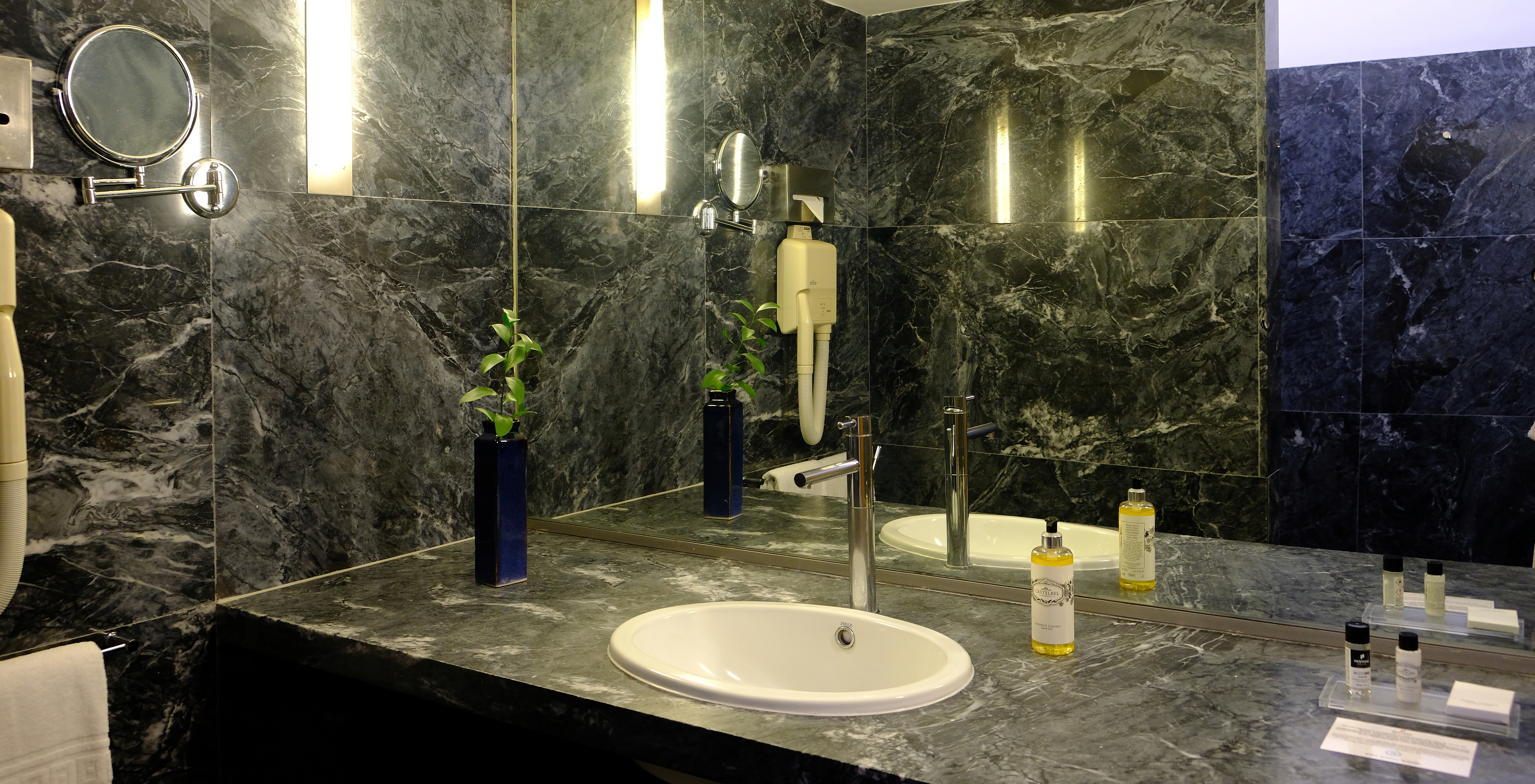 The Large Family of The Pousada Convento Arraiolos has a dark marble bathroom with a large counter and a sink