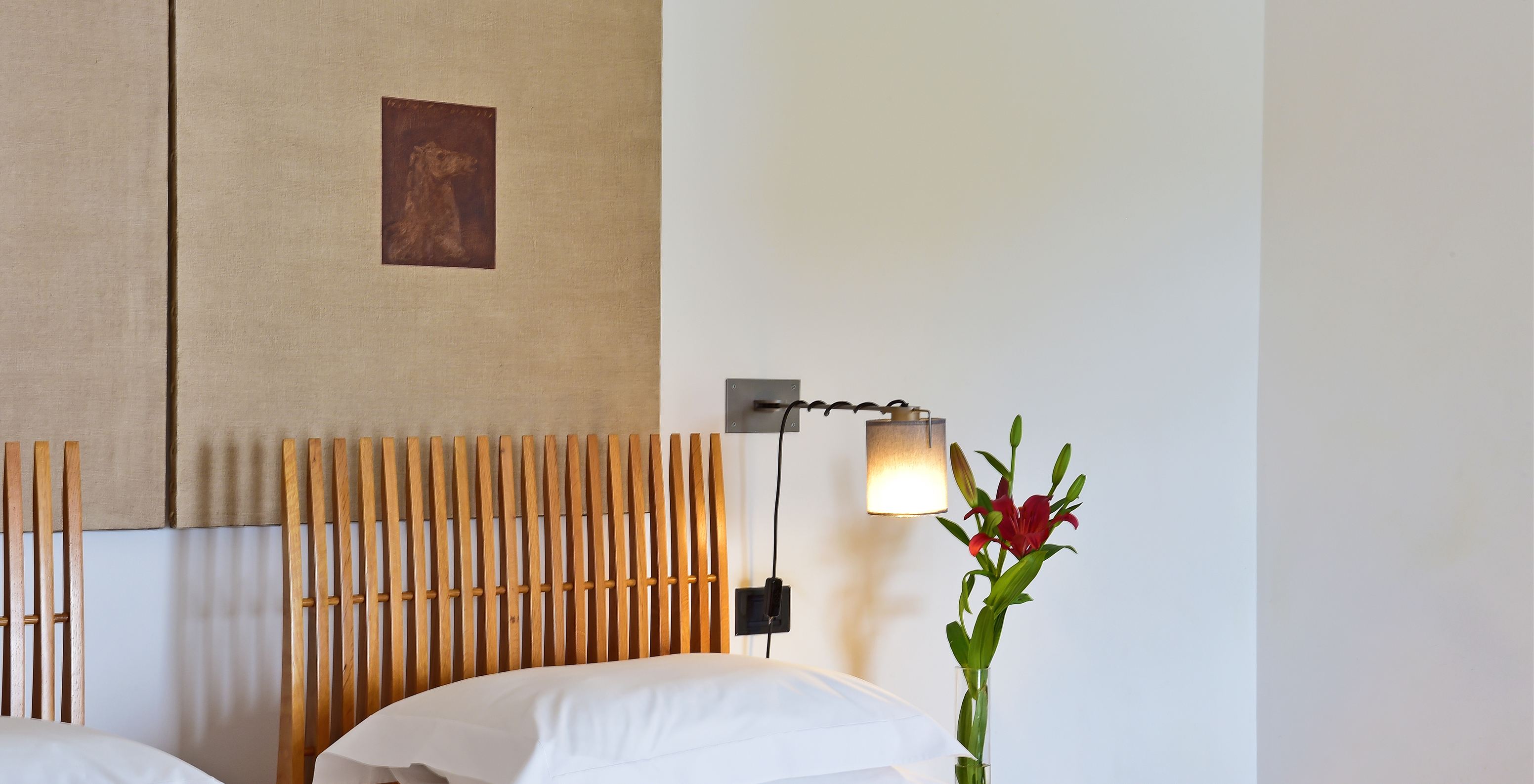 The Superior Room of The Pousada Convento Arraiolos has two single beds and a bedside table decorated with flowers