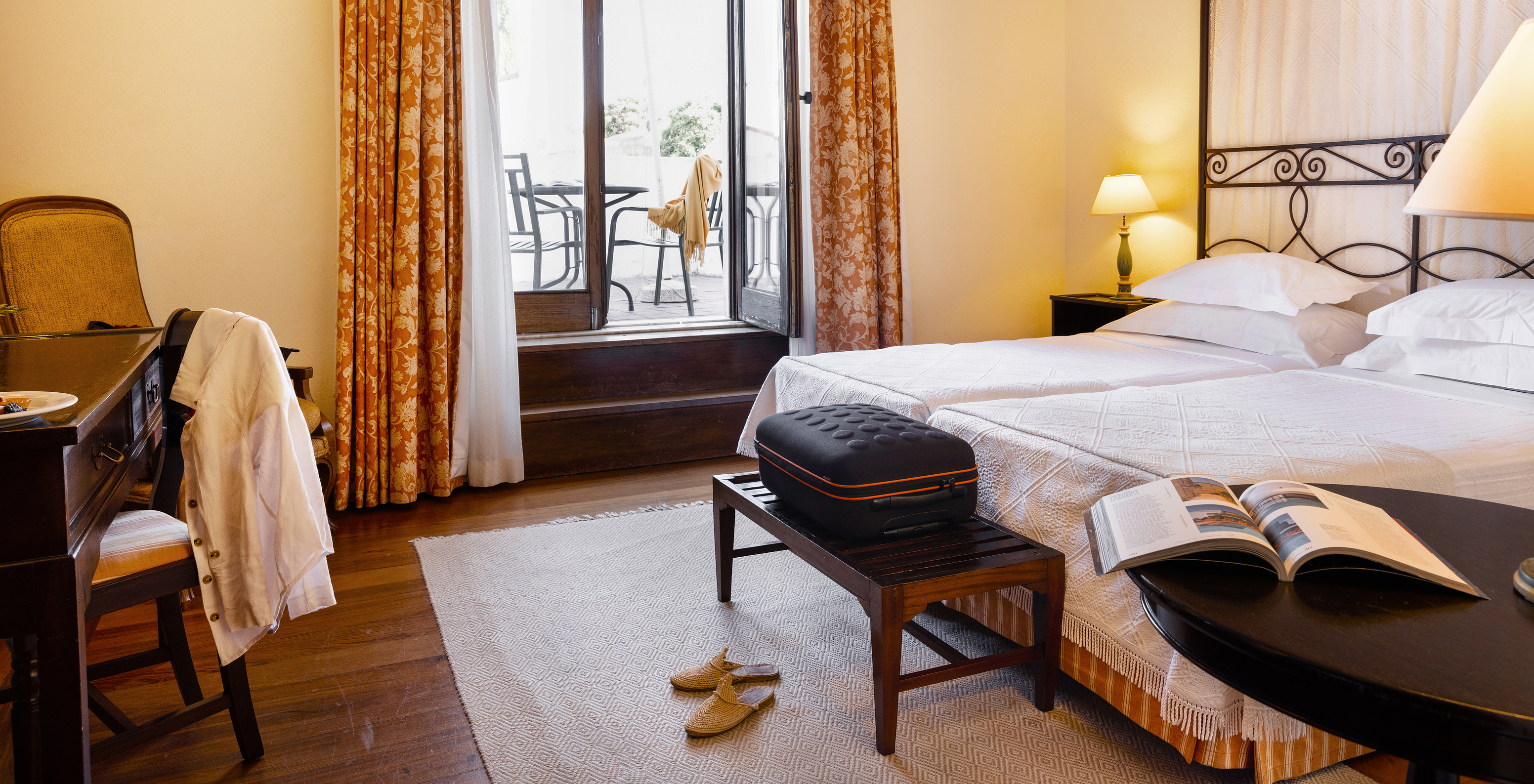 The Classic Room of The Pousada Convento Vila Viçosa has two joined beds, a bench, and luggage support and a terrace