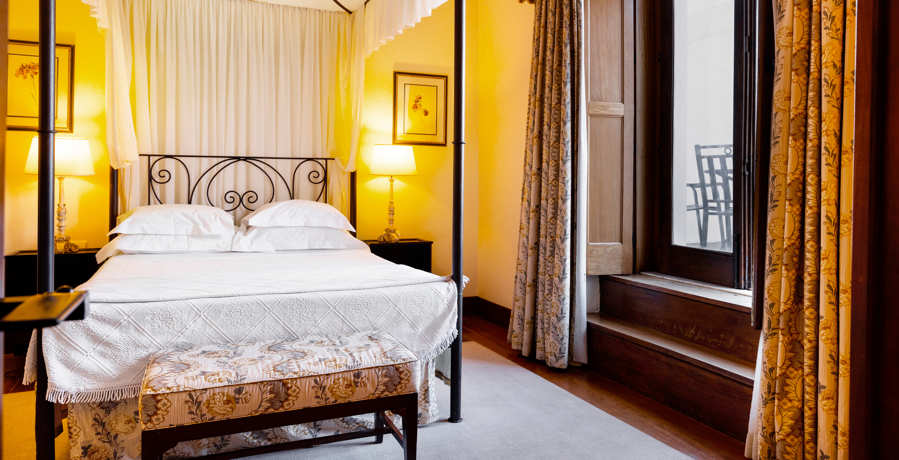 The Special Suite of The Pousada Convento Vila Viçosa has a double bed with a footrest bench at the foot of the bed