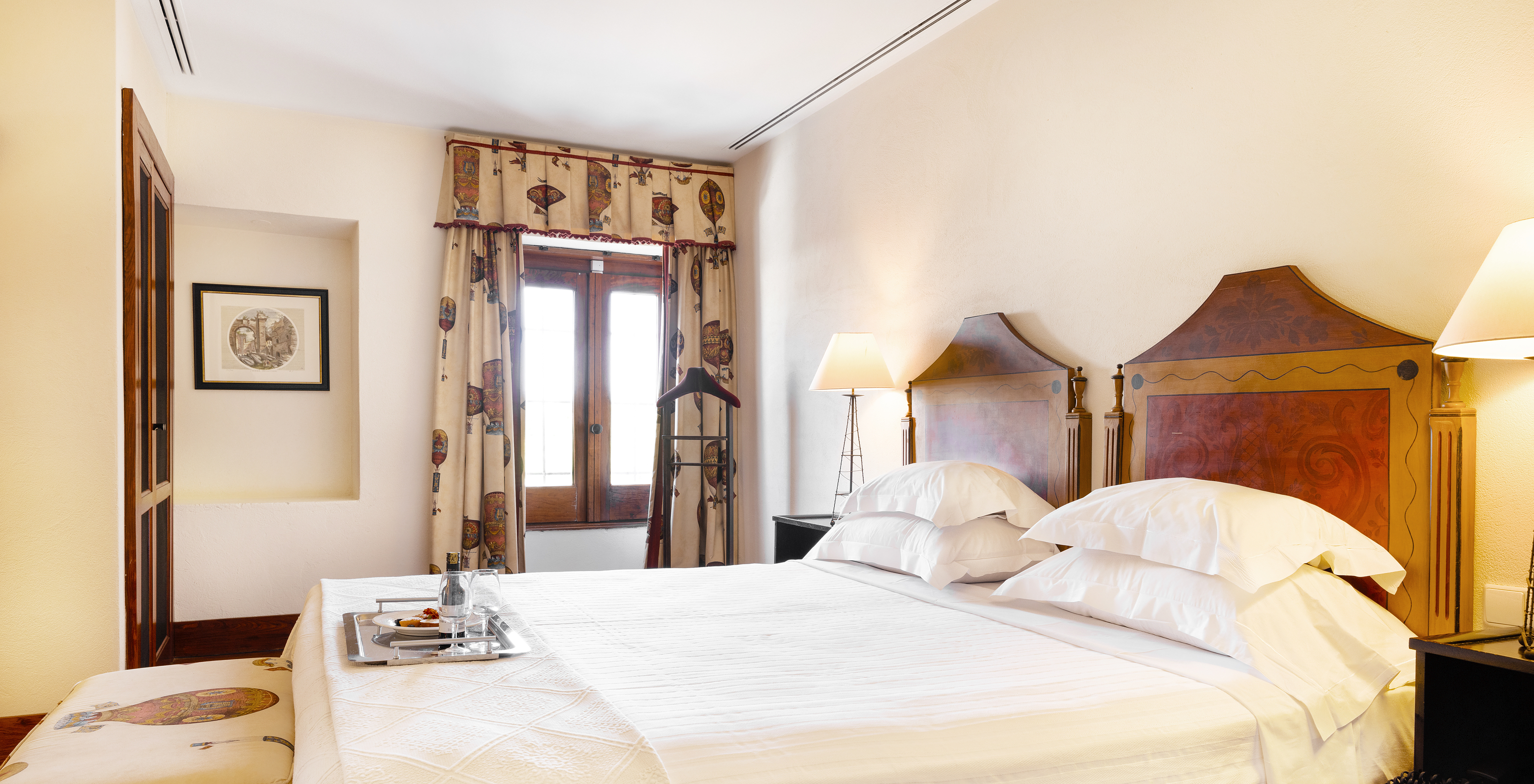 The Suite of The Pousada Convento Vila Viçosa has two joined beds with a tray with two glasses and a window