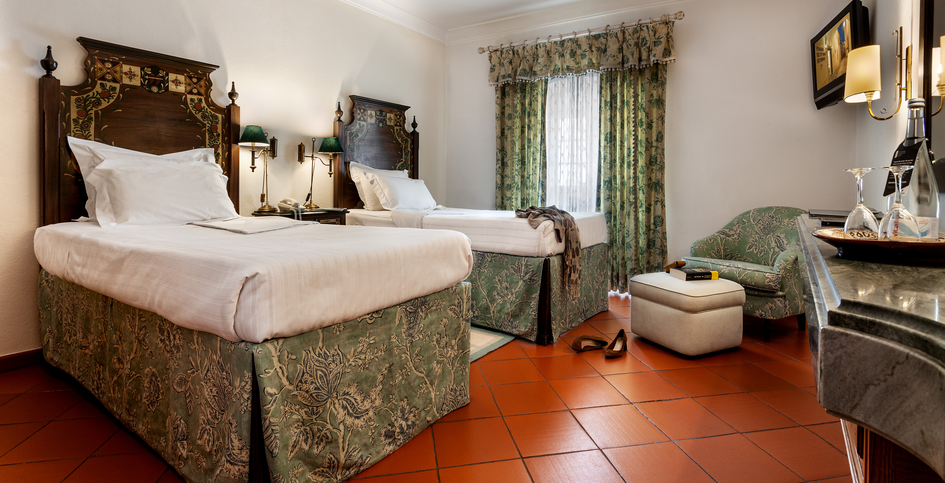 The Family Suite of The Pousada Marvão features two separate beds with a floral pattern and a counter