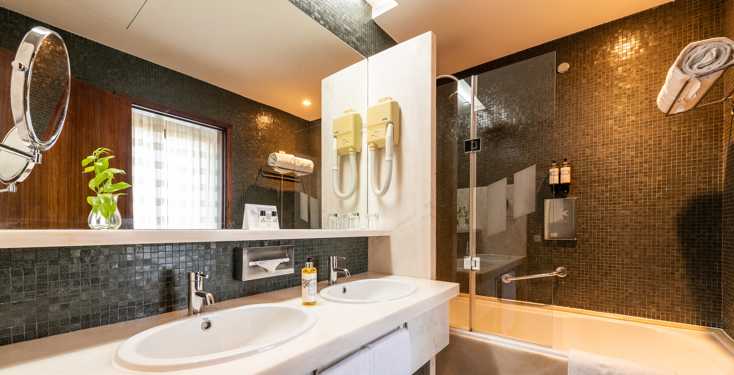 The Classic Room of The Pousada Mosteiro Crato has a bathroom with black tiles, a bathtub, and two sinks