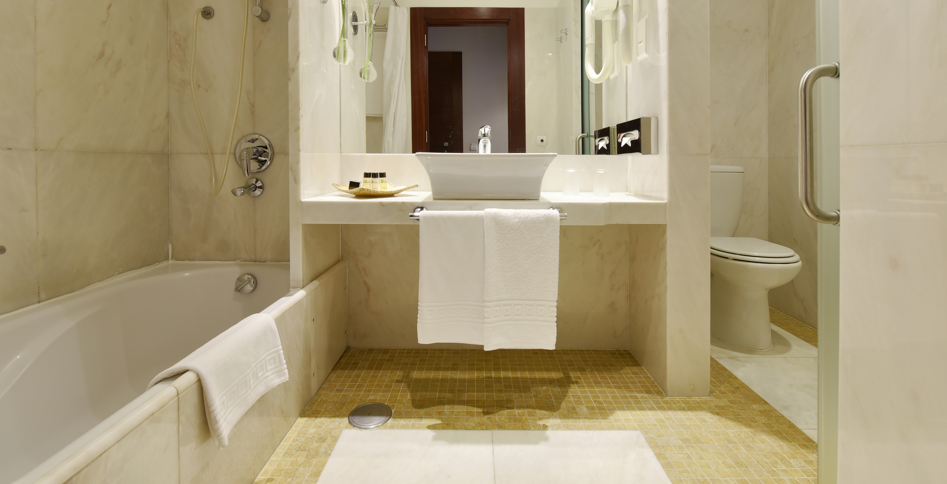 The Classic Room of The Pousada Convento Tavira has a bathroom with a bathtub, sink with mirror, amenities, and toilet