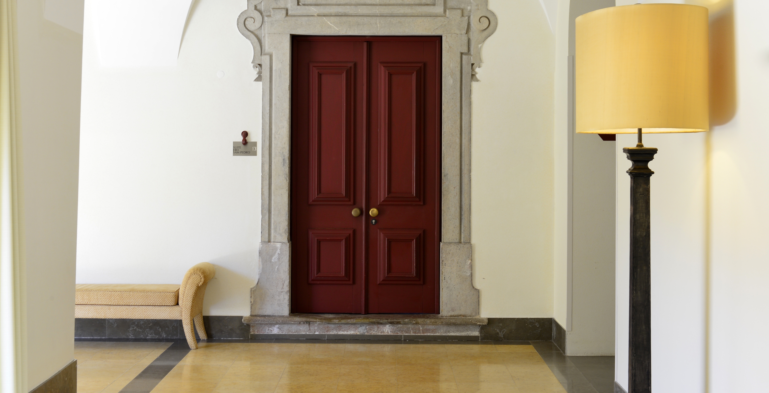 Room door with a sign reading "Suite Frei Sam Pedro" at Pousada Convento Tavira, a hotel in Tavira with pool