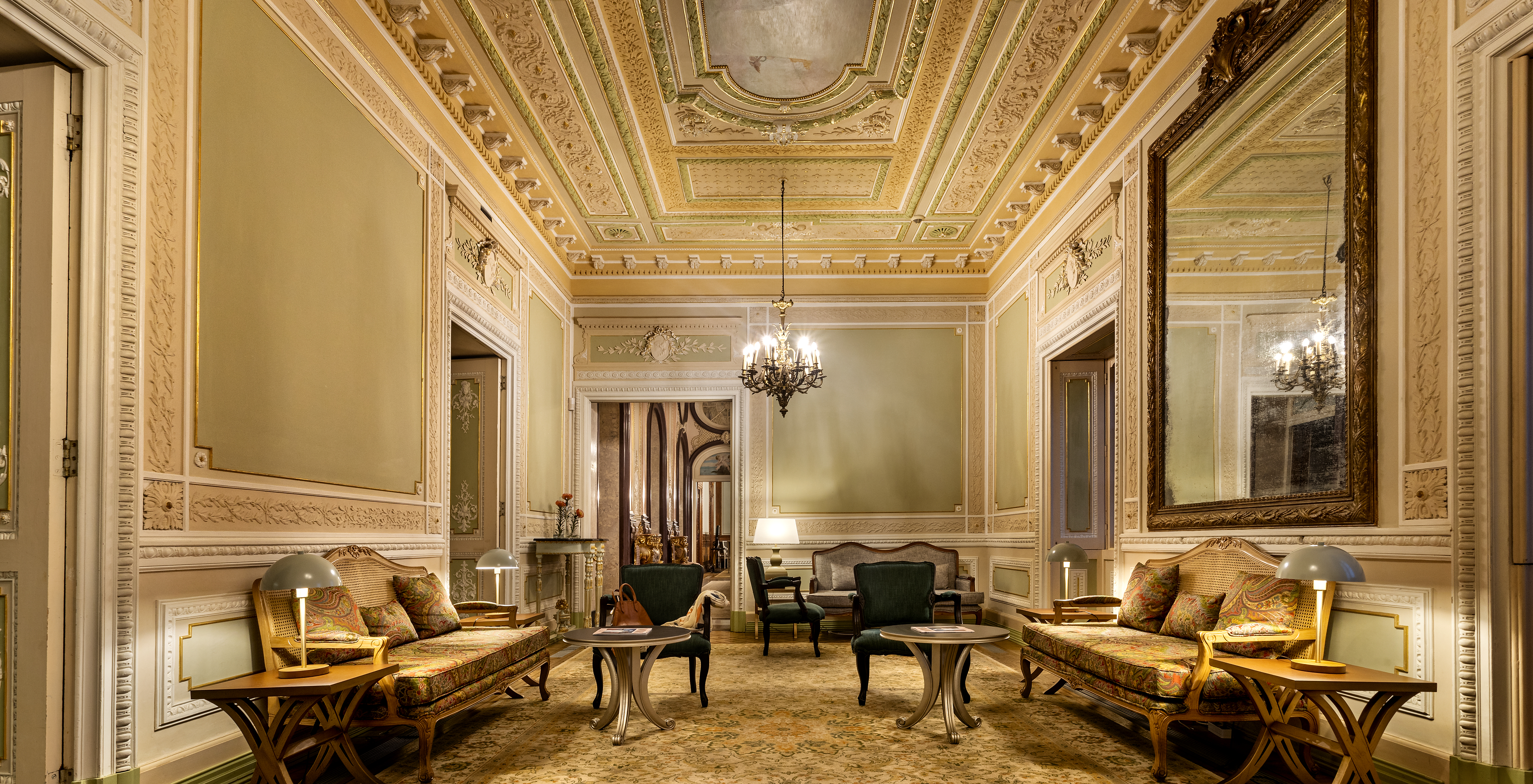 Hall of the Pousada Palácio Estoi, a historic hotel in the Algarve with a pool, with an adorned ceiling, classic sofas