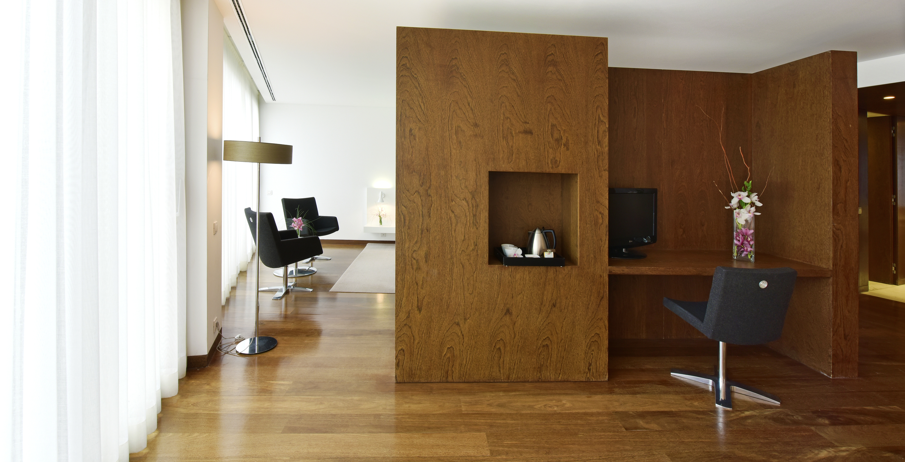 The Special Suite of The Pousada Palácio Estoi has a desk with a vase of flowers and a television monitor