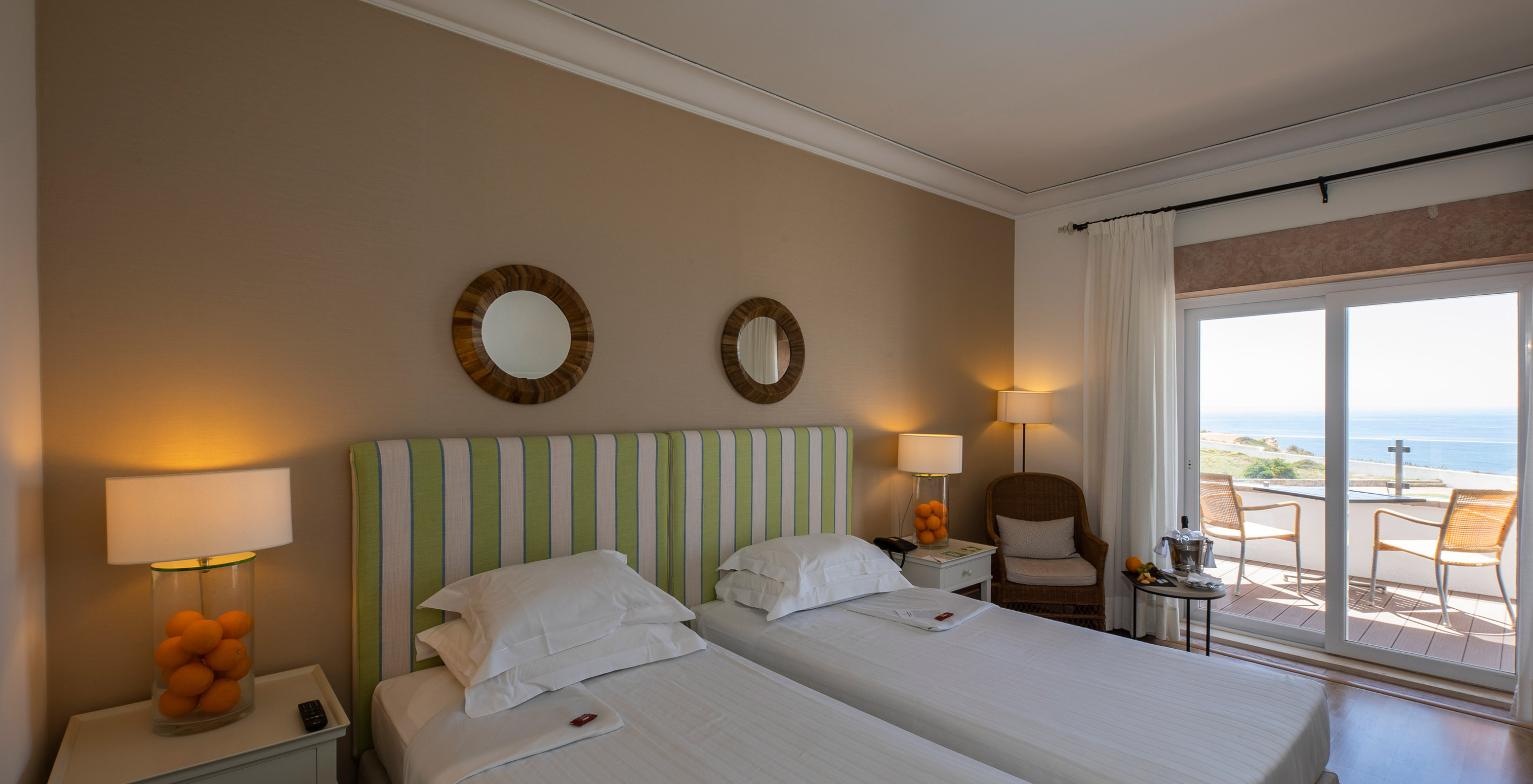 The Superior Premium Sea View Room of Pousada Sagres has two beds with striped headboards, two mirrors, and a balcony