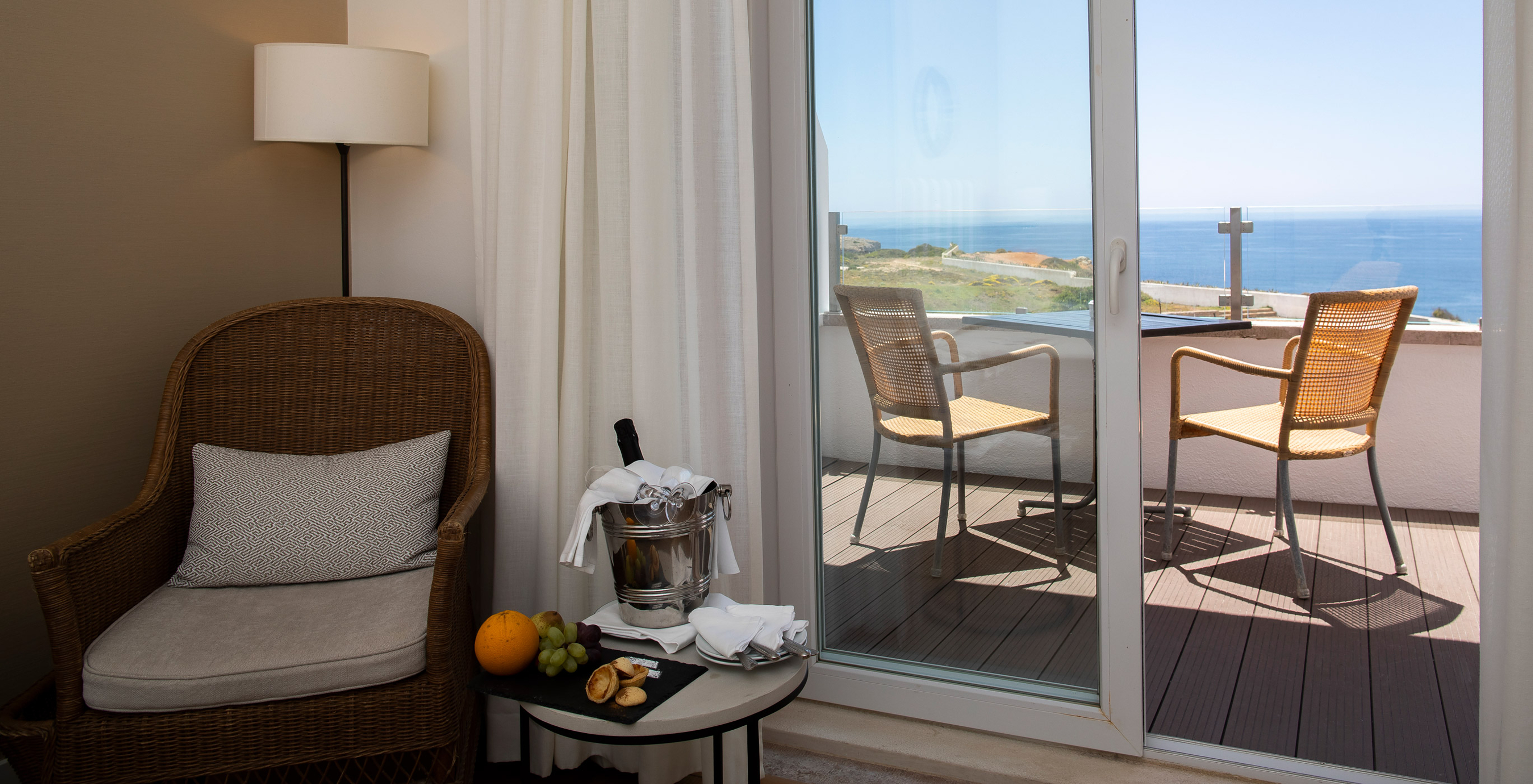 The Superior Premium Sea View Room of Pousada Sagres has a balcony with table and chairs and an armchair