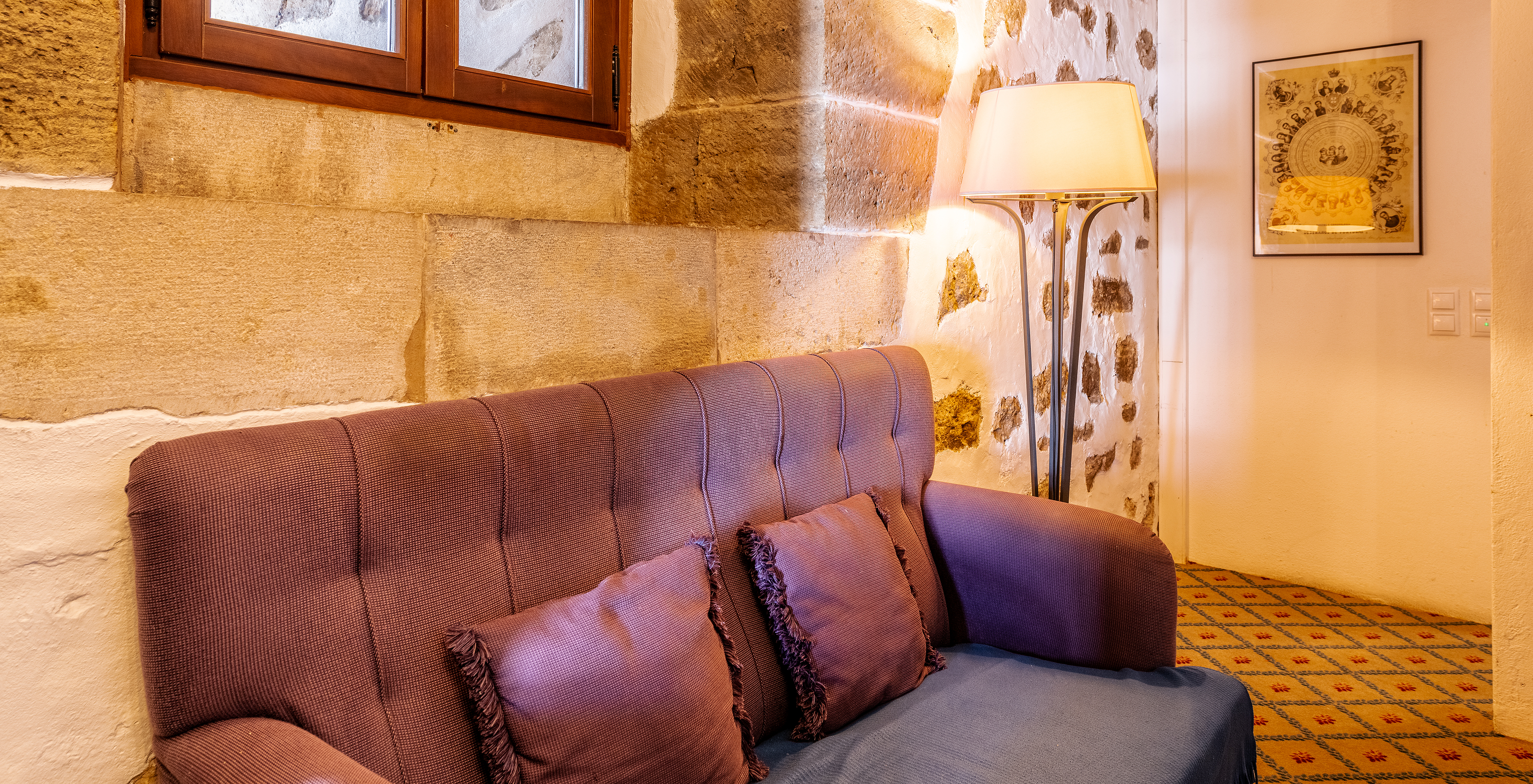 The Special Suite at Pousada Castelo Óbidos has a comfortable sofa, with a lamp and a painting