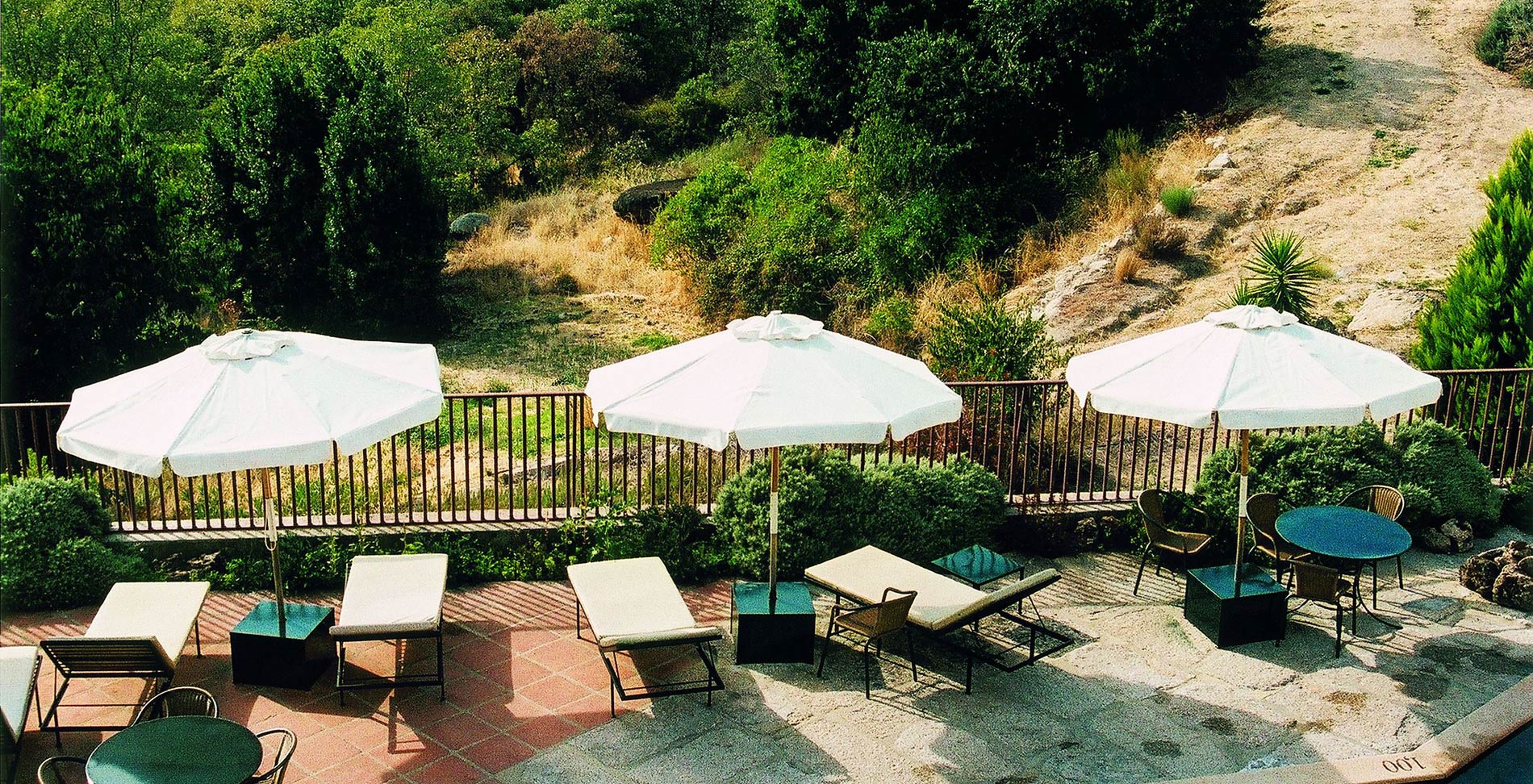 Stone terrace at Pousada Convento de Belmonte, a hotel in central Portugal, with sun loungers and umbrellas