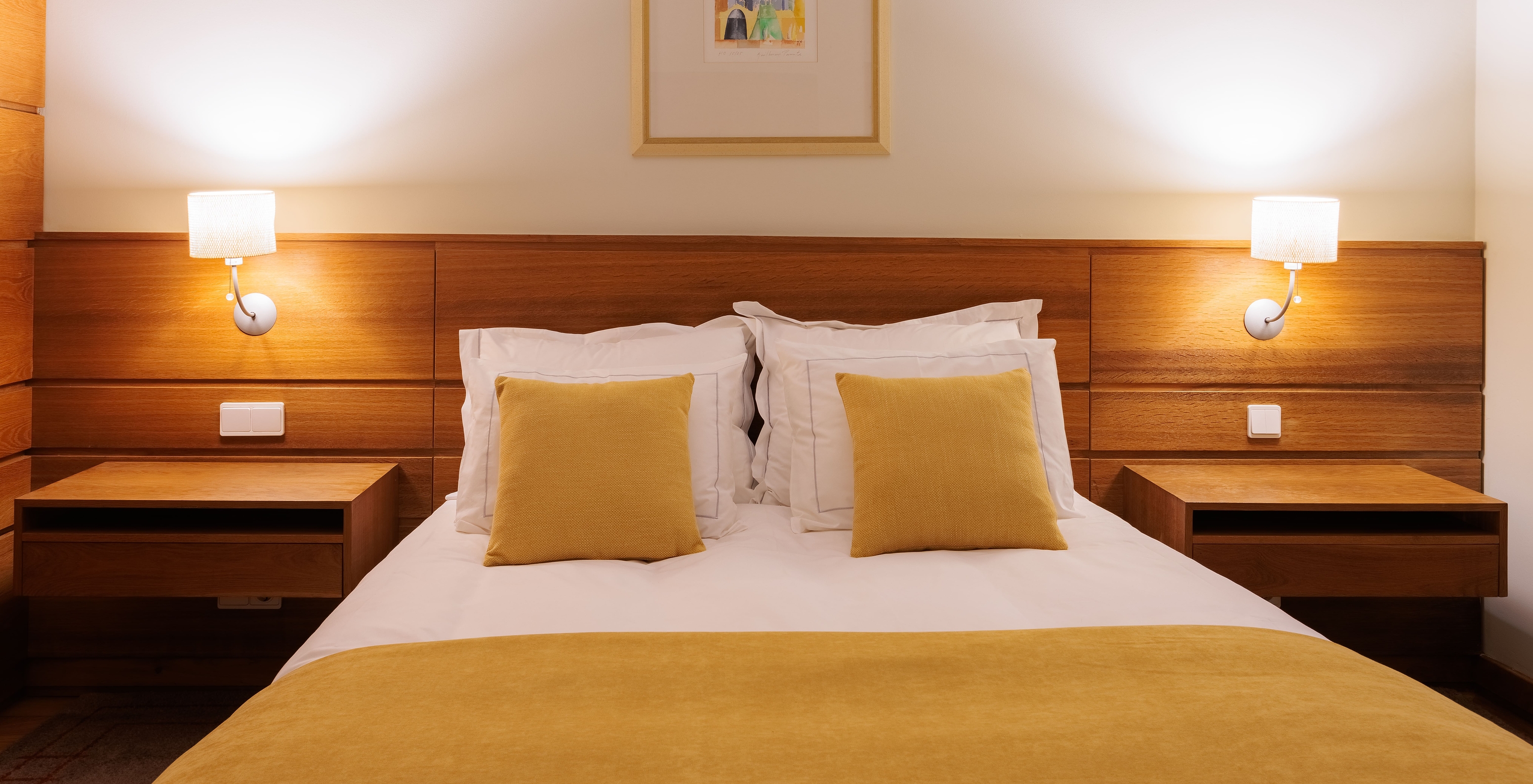 The Single Room of The Pousada Ourém has a double bed with two bedside tables and a yellow bedspread