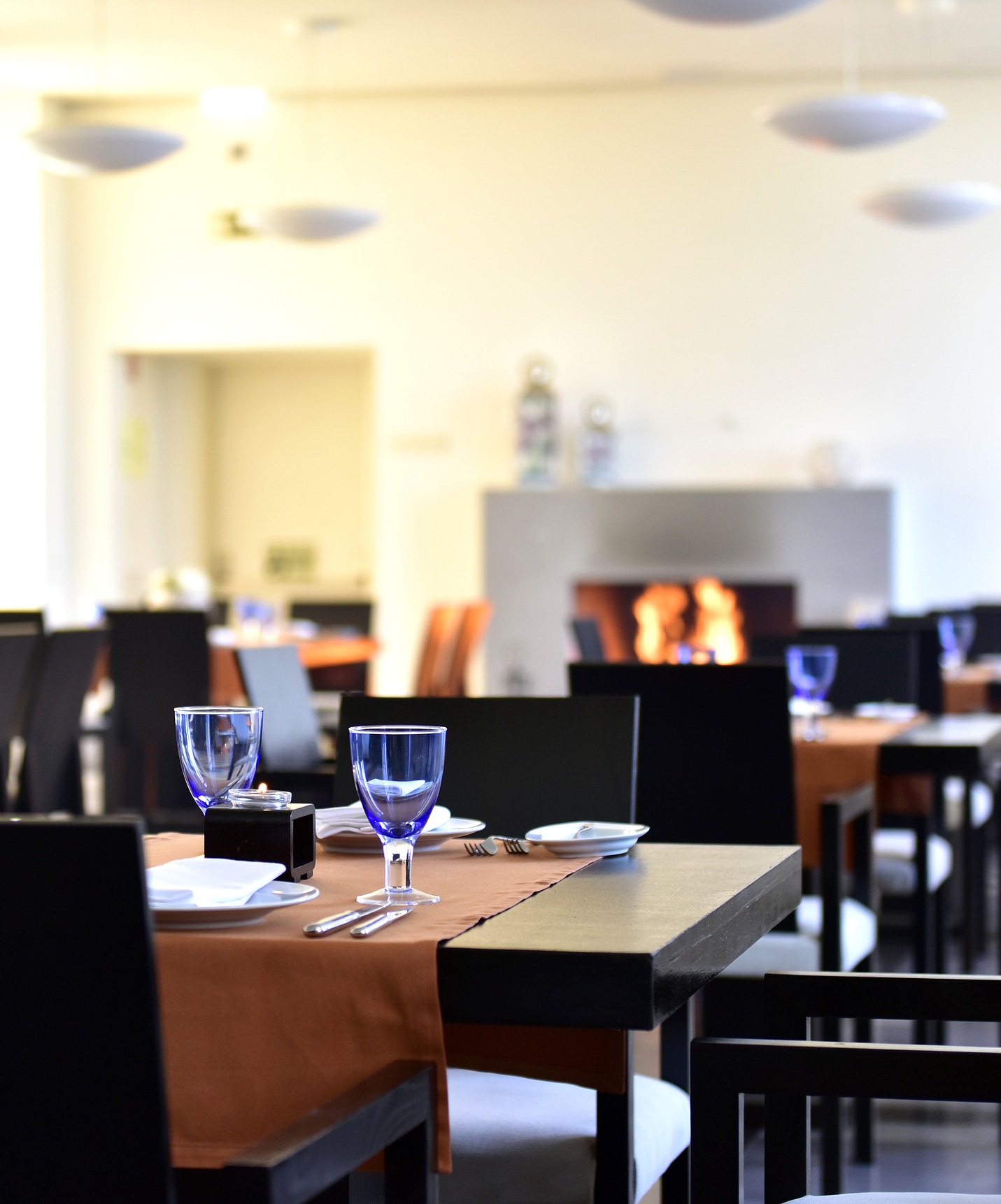 Restaurant at Mountain Hotel in Central Portugal with several tables and a stone fireplace in the background