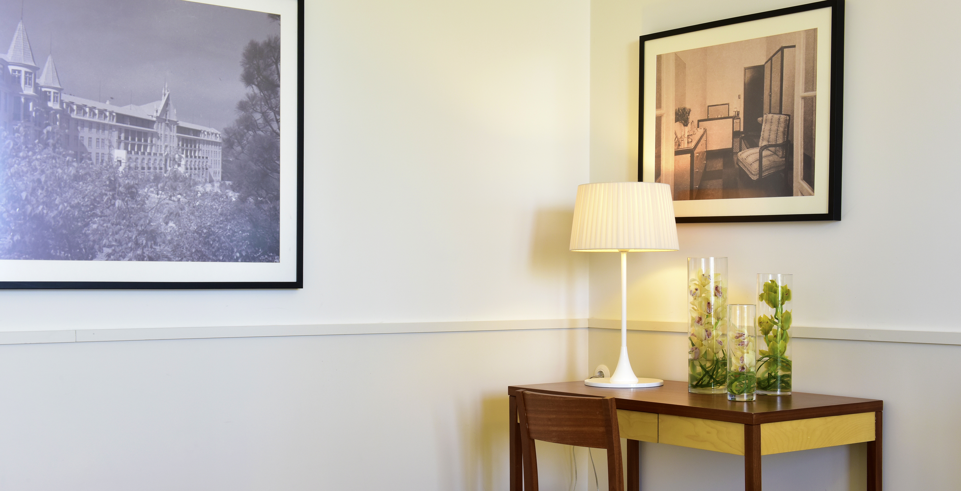 The Classic Family Room of The Serra da Estrela Inn has a desk and two paintings of the old sanatorium of Serra da Estrela