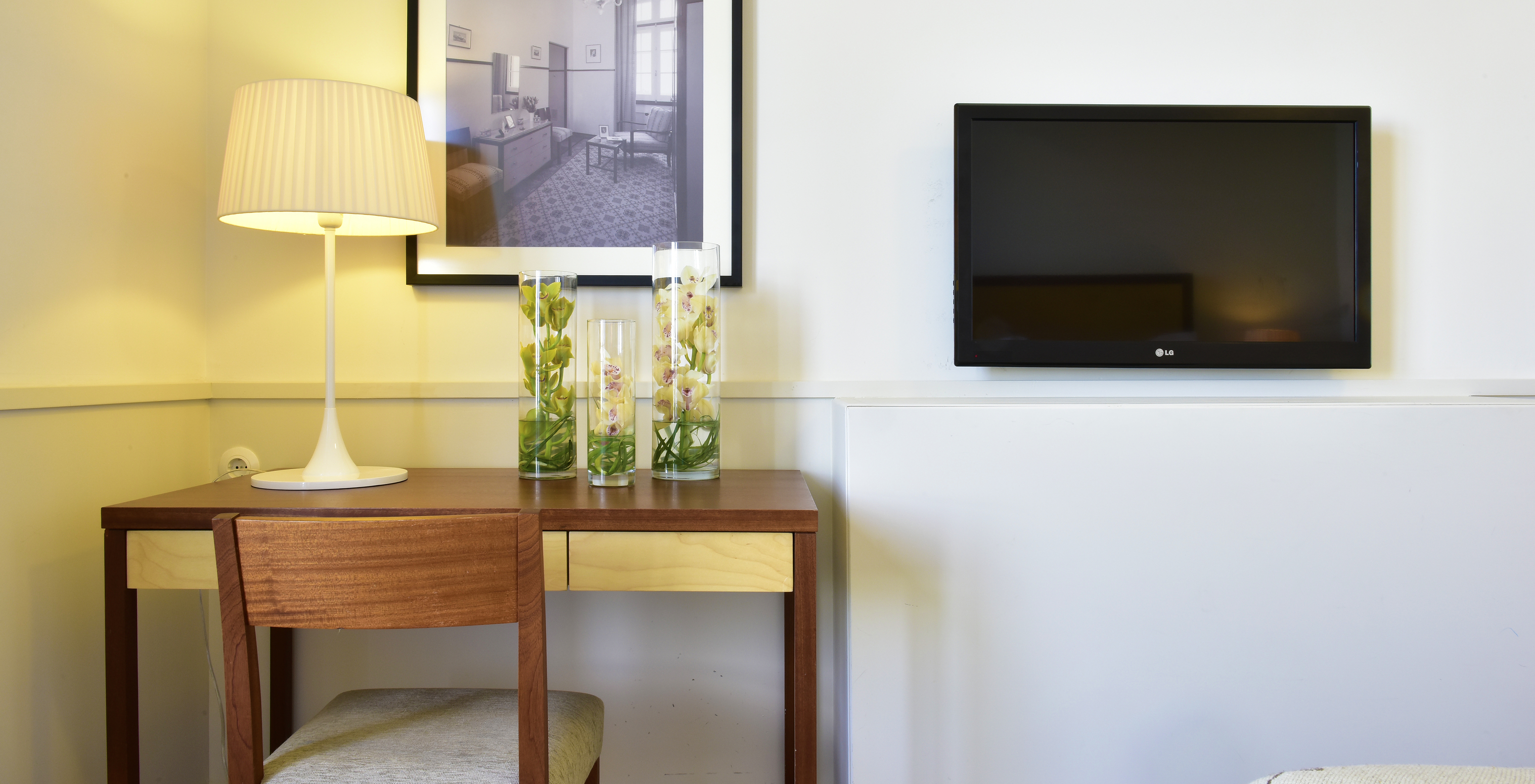 The Classic Room of The Serra da Estrela Inn has a desk, a painting of the old sanatorium, and a TV