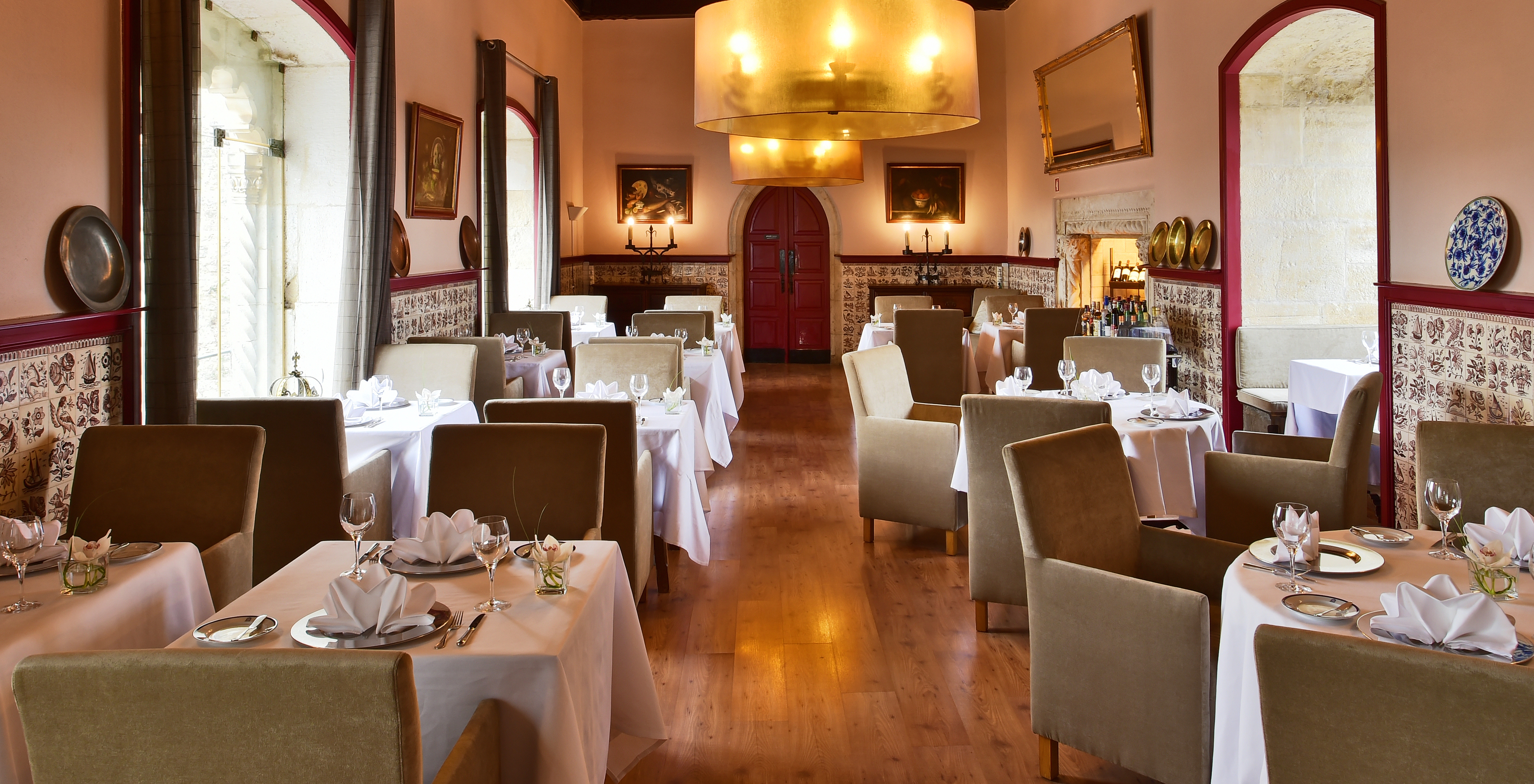 Restaurant at Pousada Vila Óbidos, Bed and Breakfast in Óbidos, with several tables, two lamps, and tiled walls