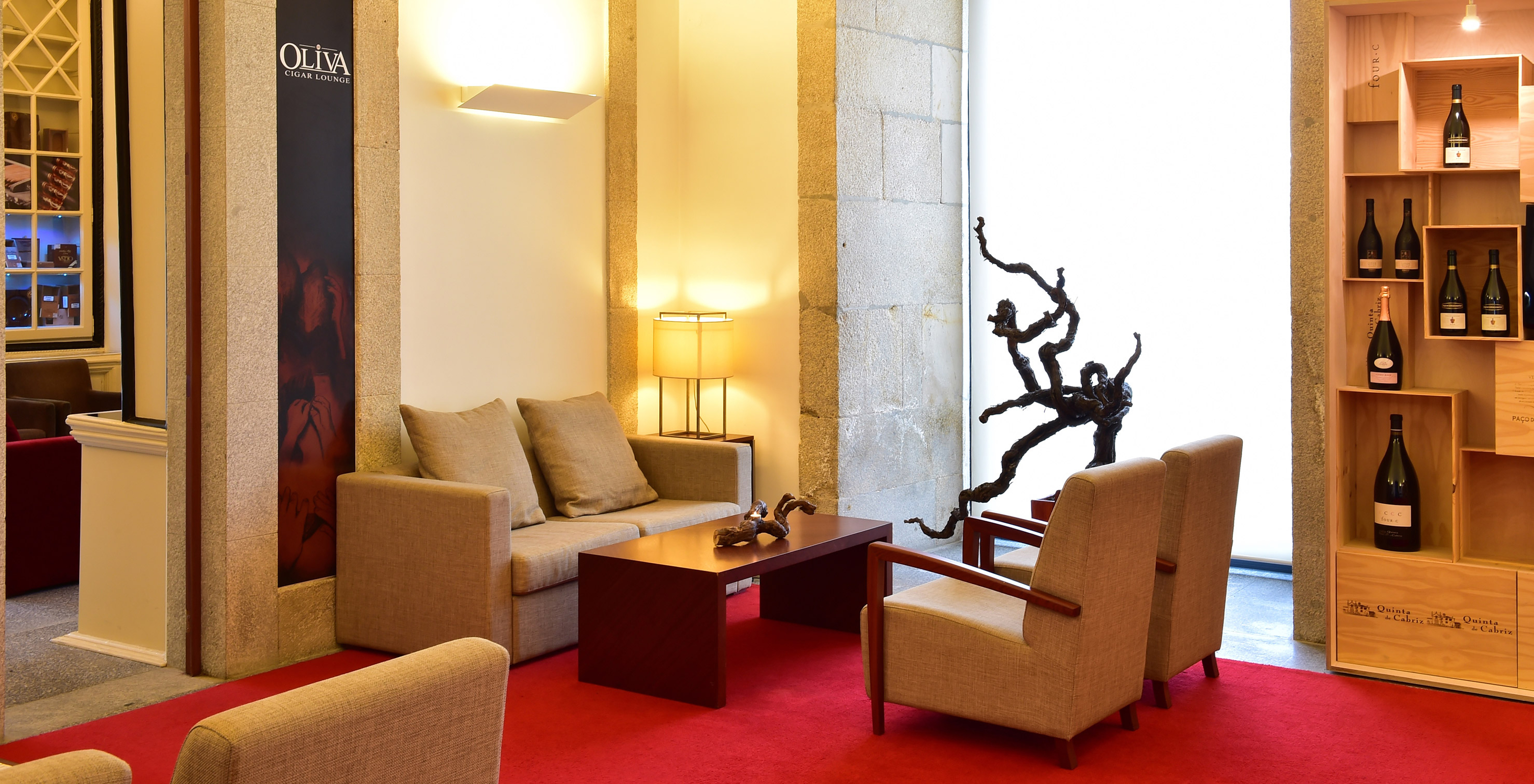 Interior space of Pousada Viseu, with two sofas and a coffee table, and a wine display cabinet