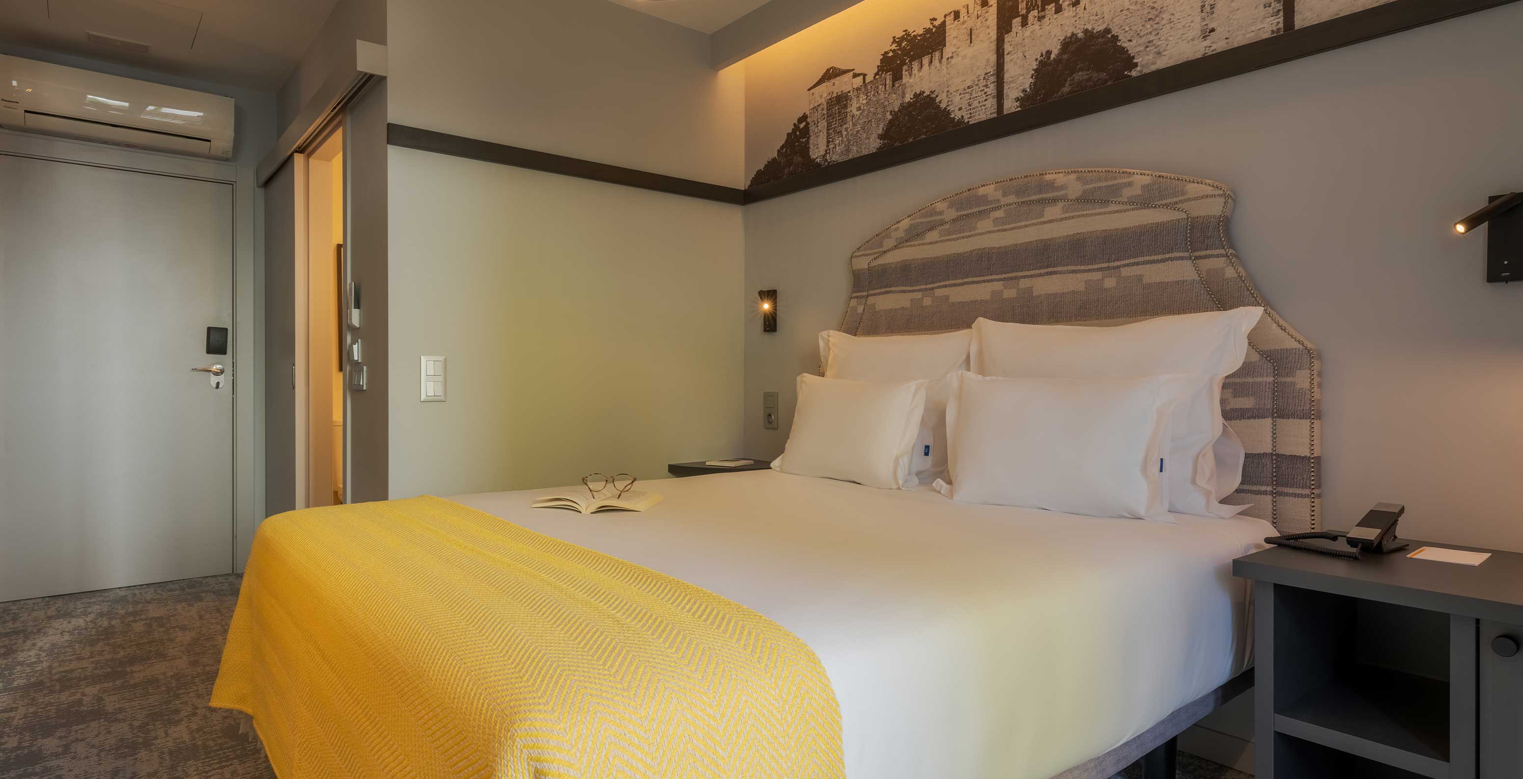 The Comfort Balcony at Pousada Alfama has a double bed and the room is decorated in yellow tones