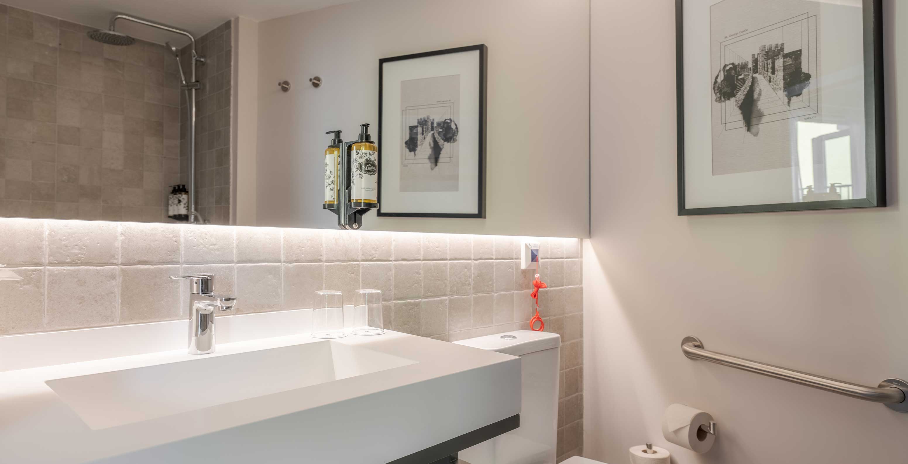 The Comfort Balcony at Pousada Alfama has a long mirror and a large sink in the bathroom