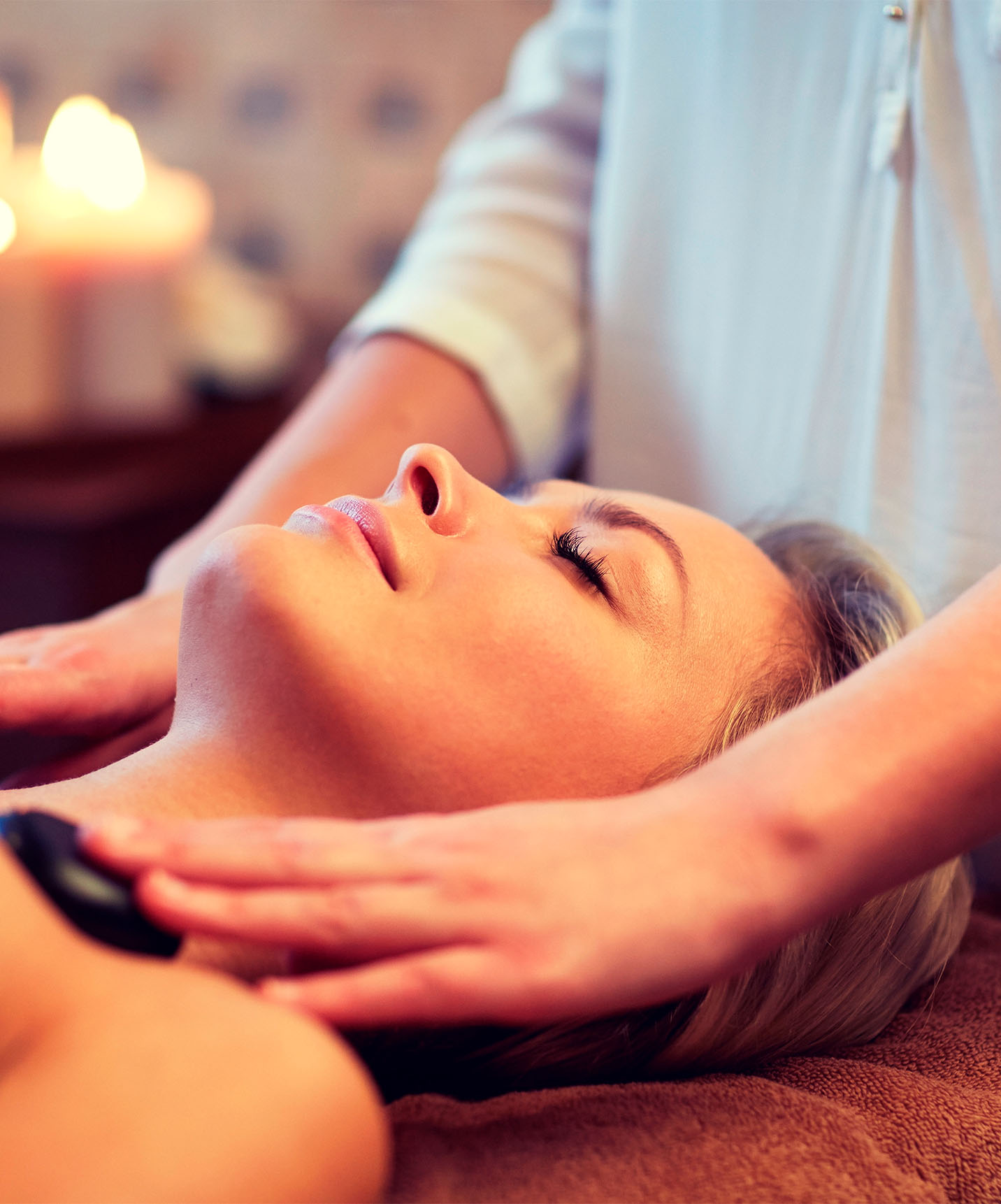 Woman receiving a hot stone massage in the massage room of the historic hotel in downtown Lisbon