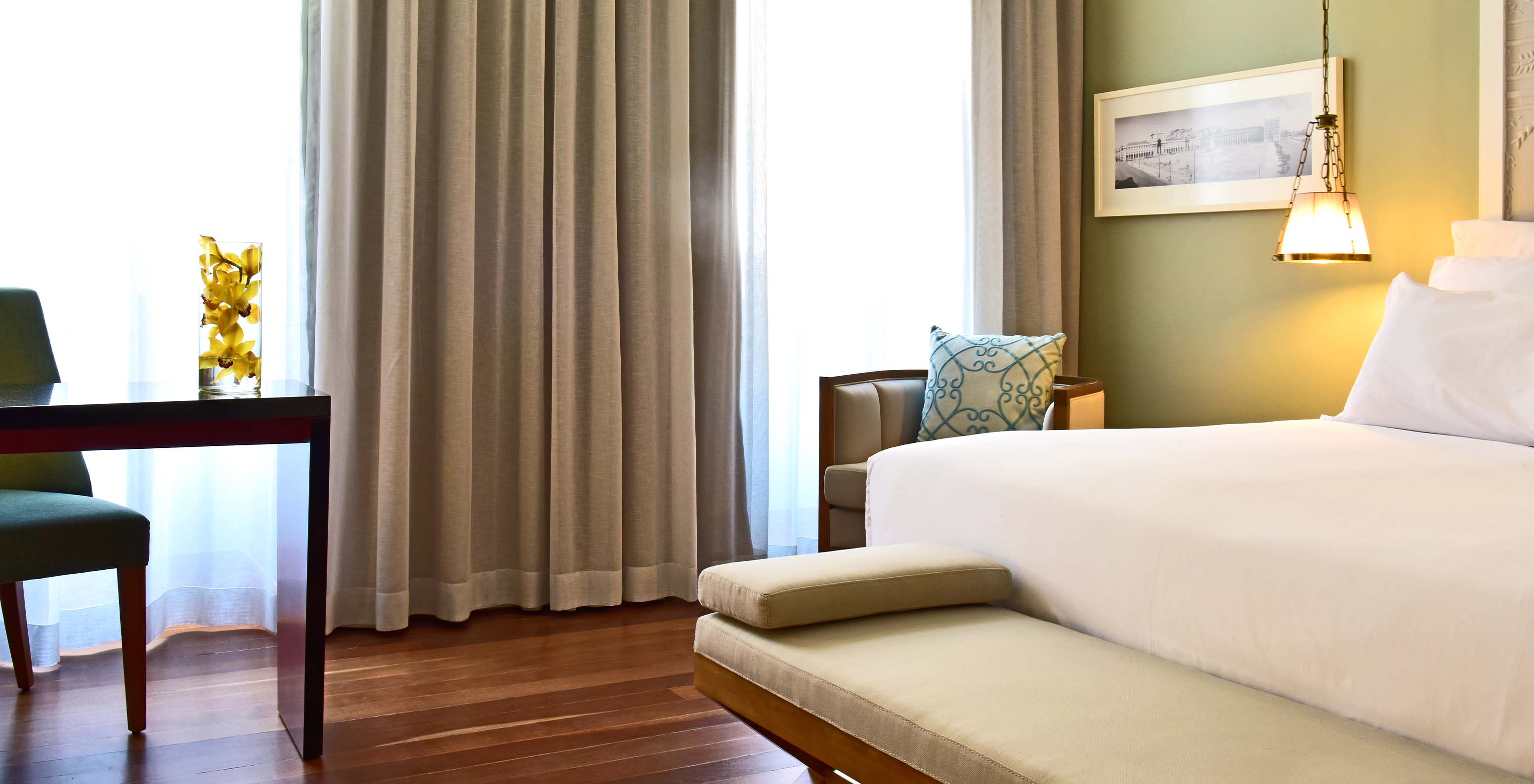 The Premium King Size Bed of The Pousada Lisboa Praça do Comércio has a double bed with a bench at the foot and large windows