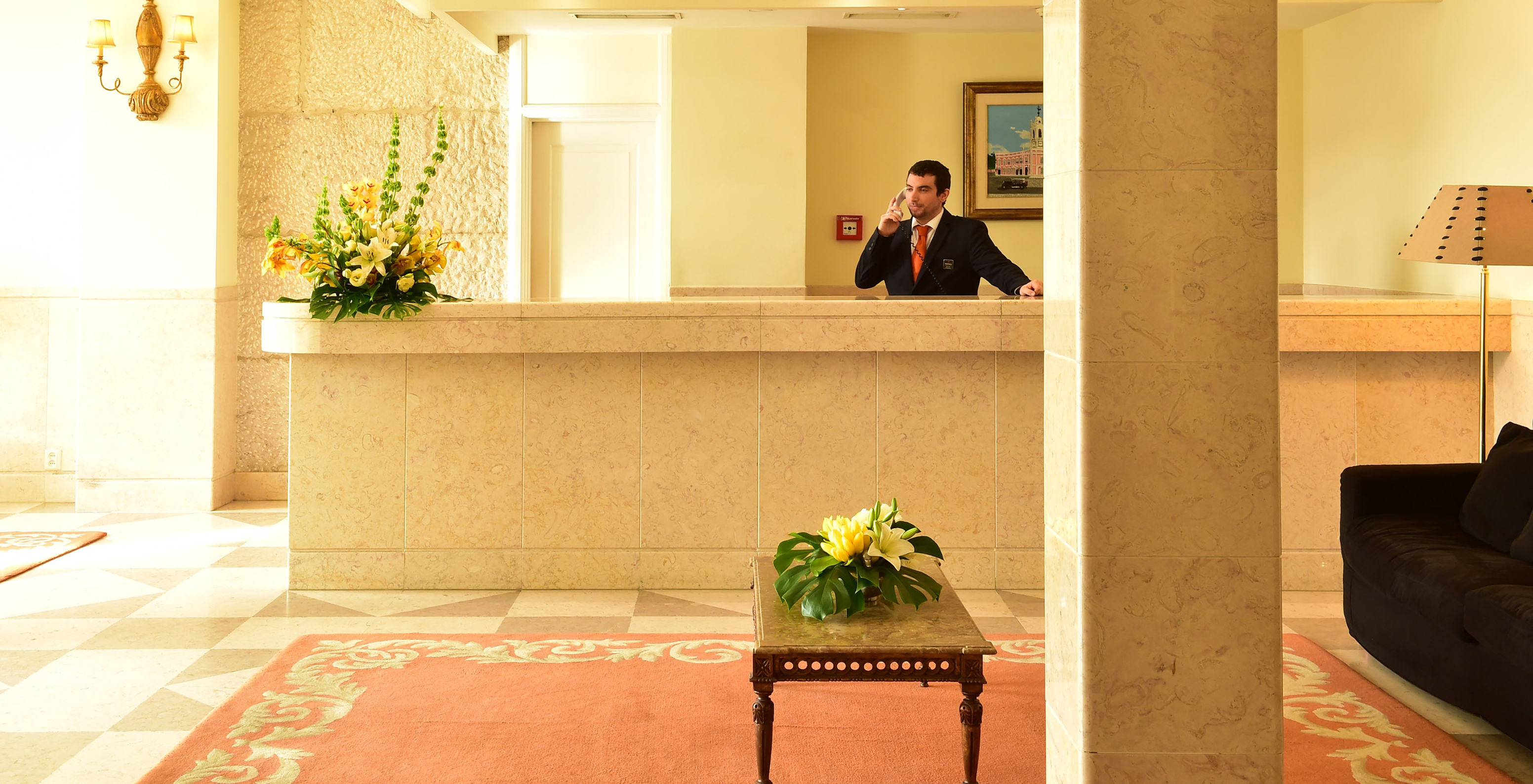 Reception of the historic hotel in Queluz, with receptionist answering the phone to assist a request