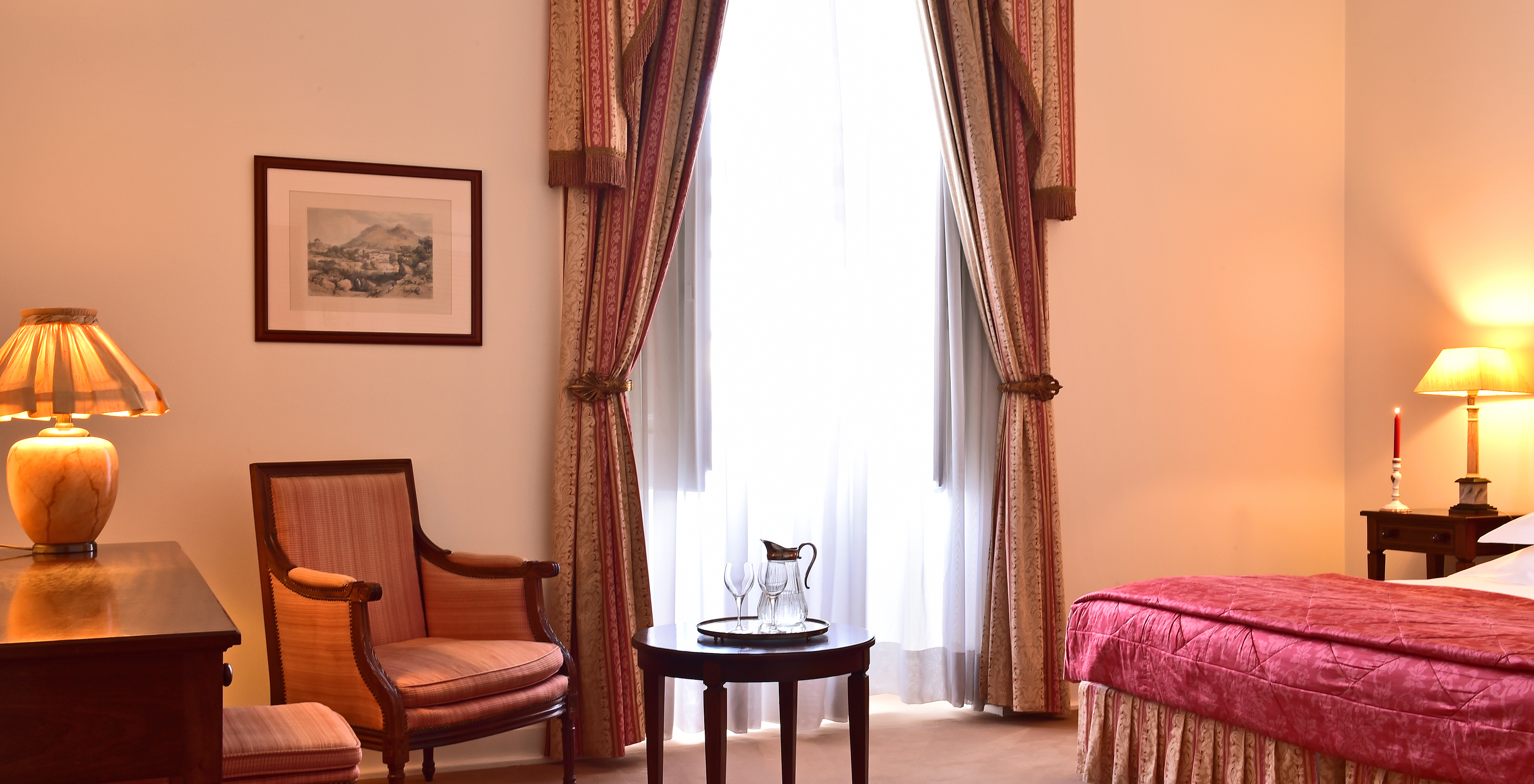 The Standard Suite of The Pousada Palácio Queluz features an armchair and a table near the bed and window where you can rest