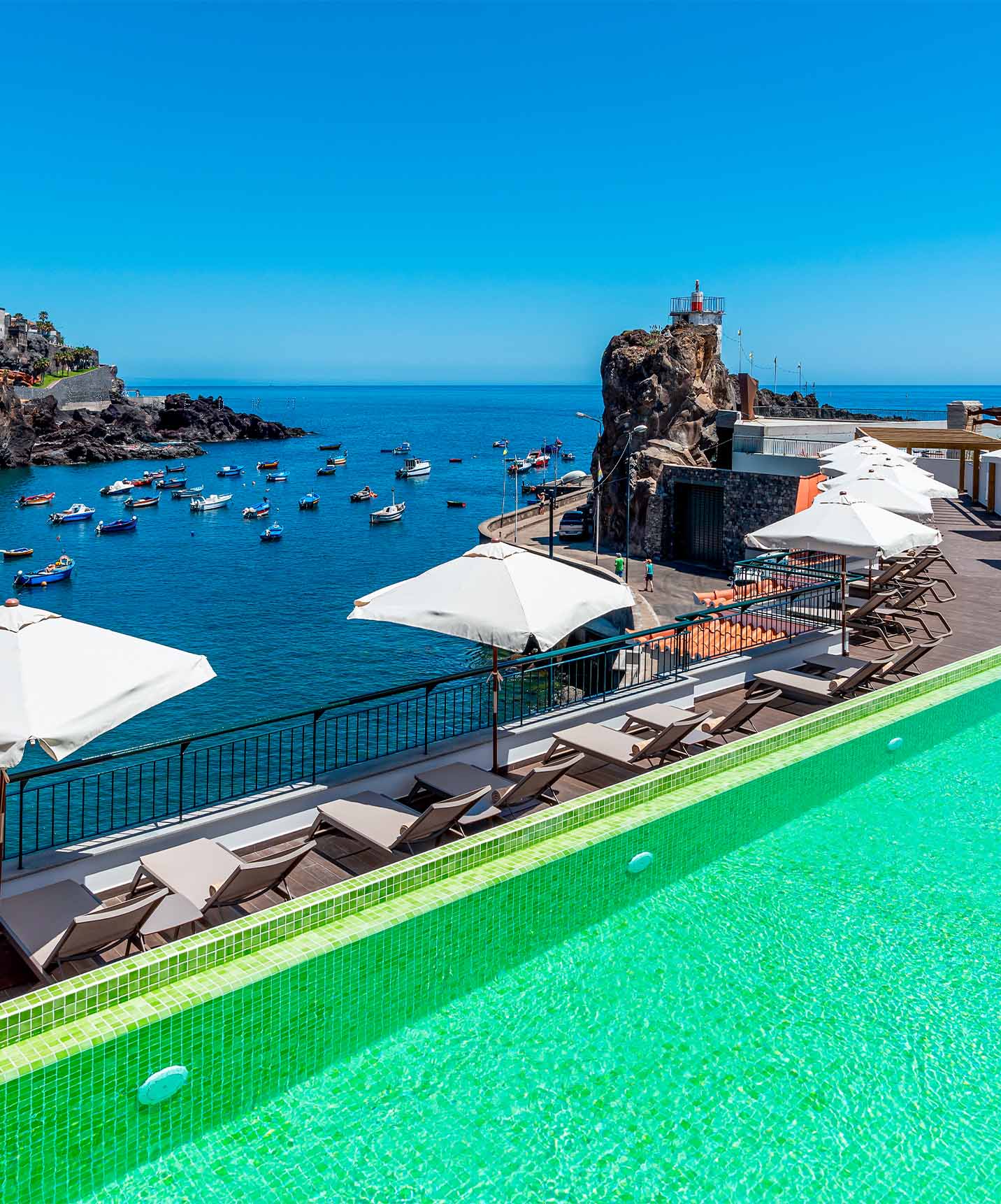 The hotel in Câmara de Lobos Bay near Funchal has an outdoor rooftop pool with views of the bay and village