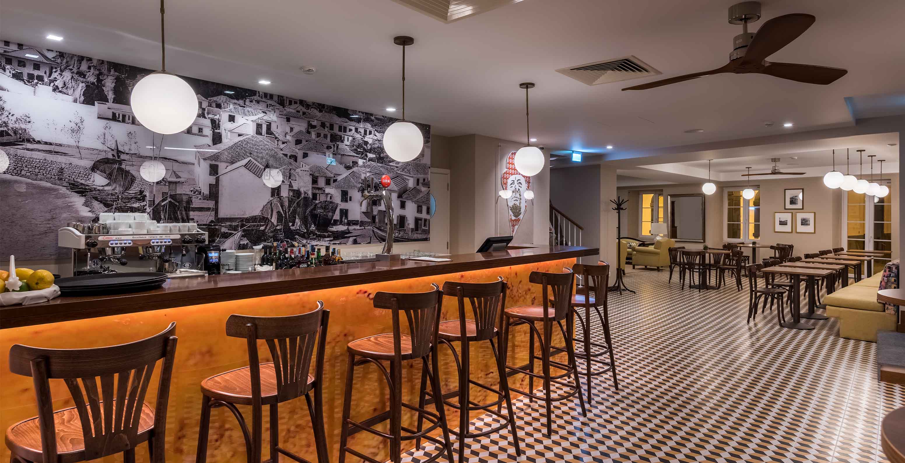 Hotel in Câmara de Lobos Bay, near Funchal, has a modern bar with high stools at the counter and tables in the back