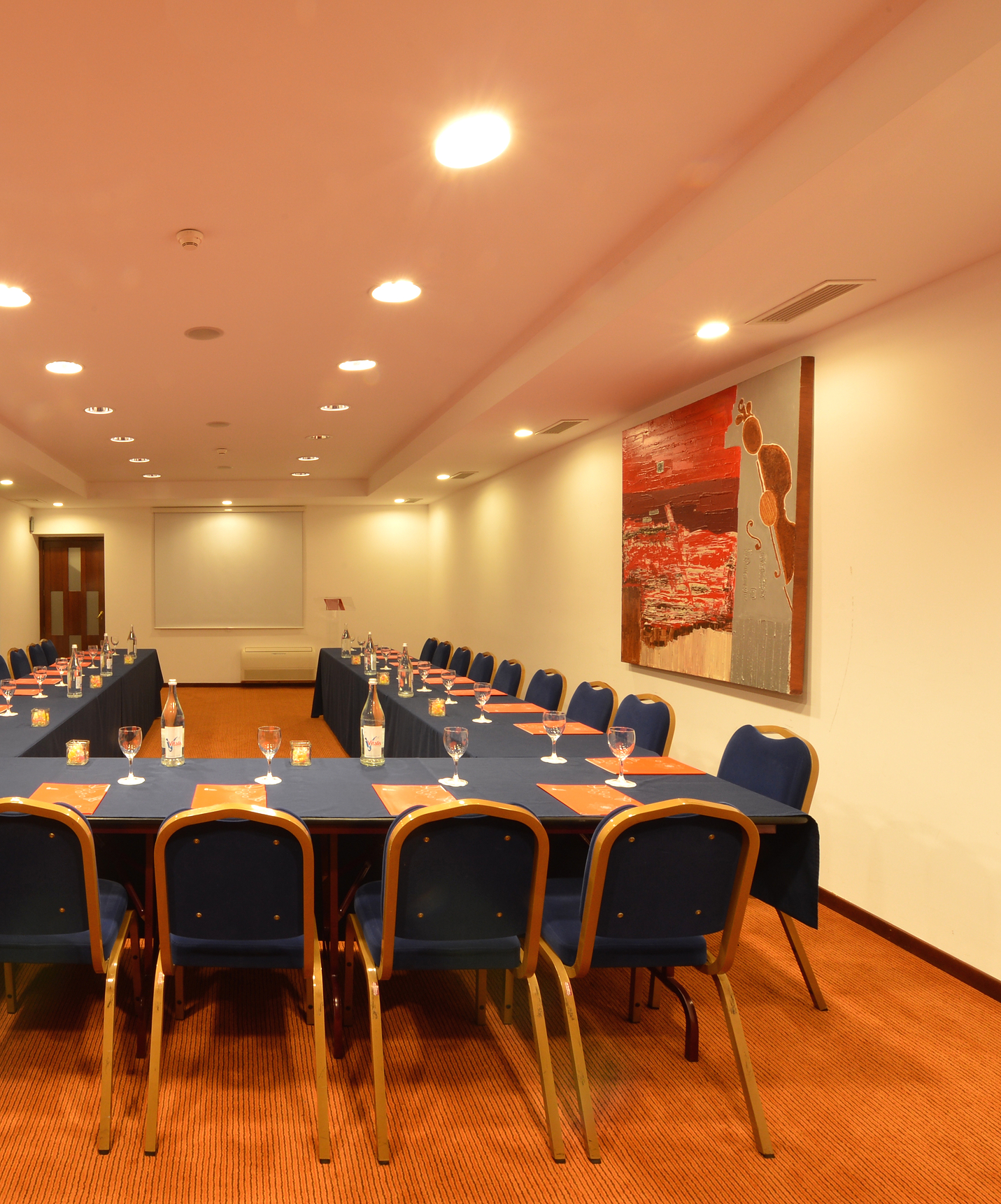 Meeting room of the Mountain Hotel in Gerês, with a large table and several chairs around and a decorative board