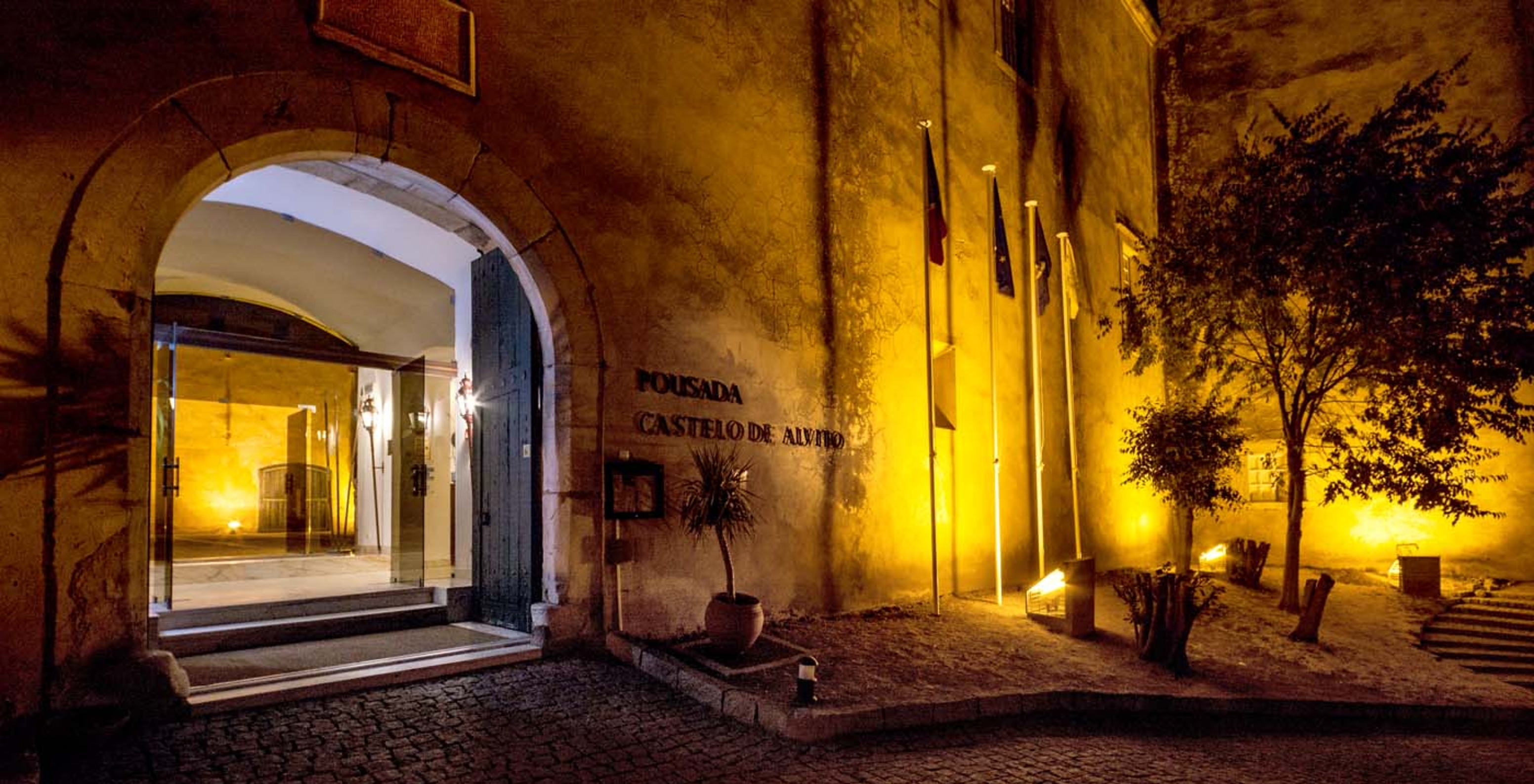 Entrada de la Pousada Castelo Alvito, con la fachada del Castillo y una placa donde se lee el nombre del hotel