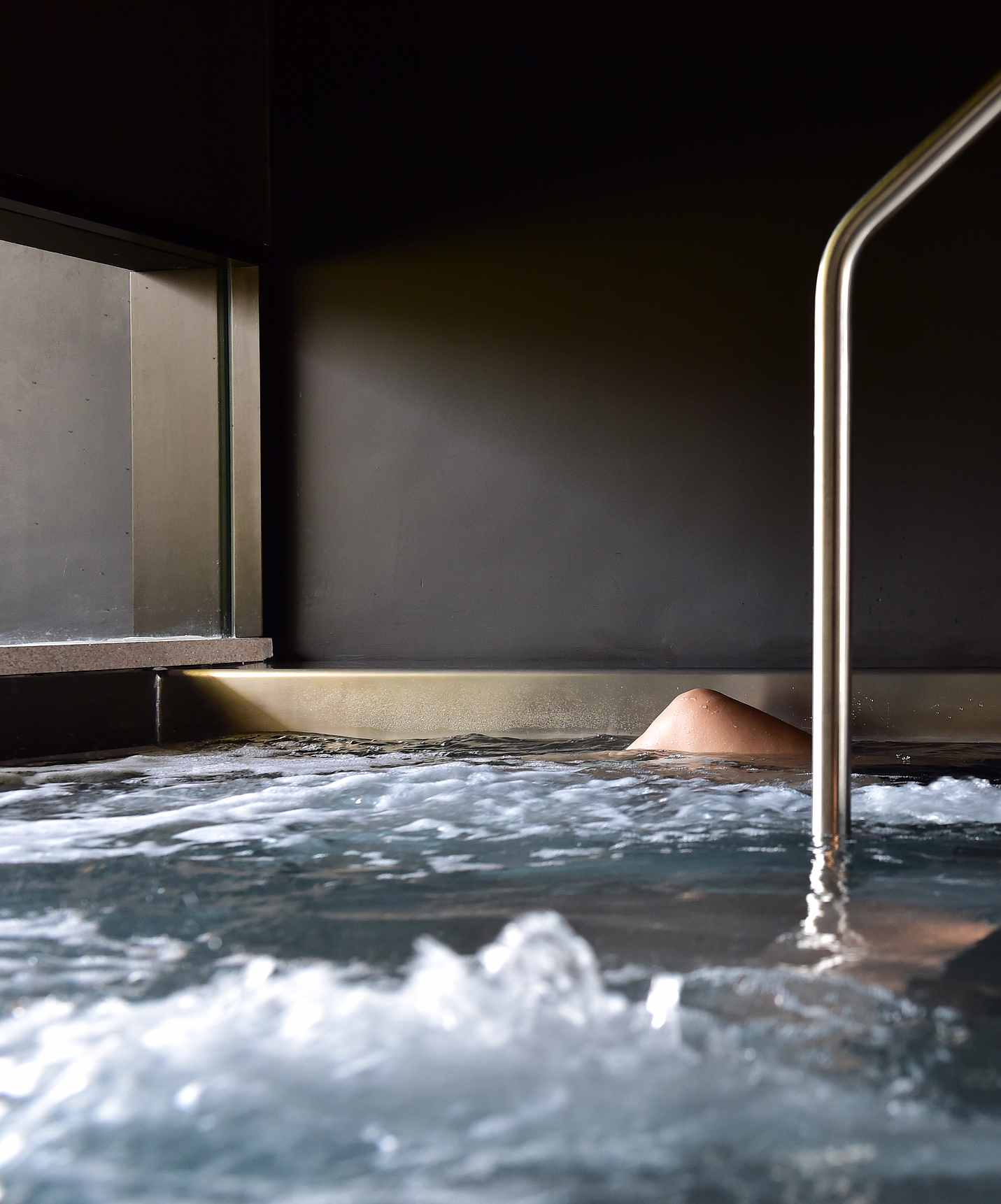 Chica relajándose en la piscina interior de la Pousada Palácio Estoi, Hotel Histórico en Algarve