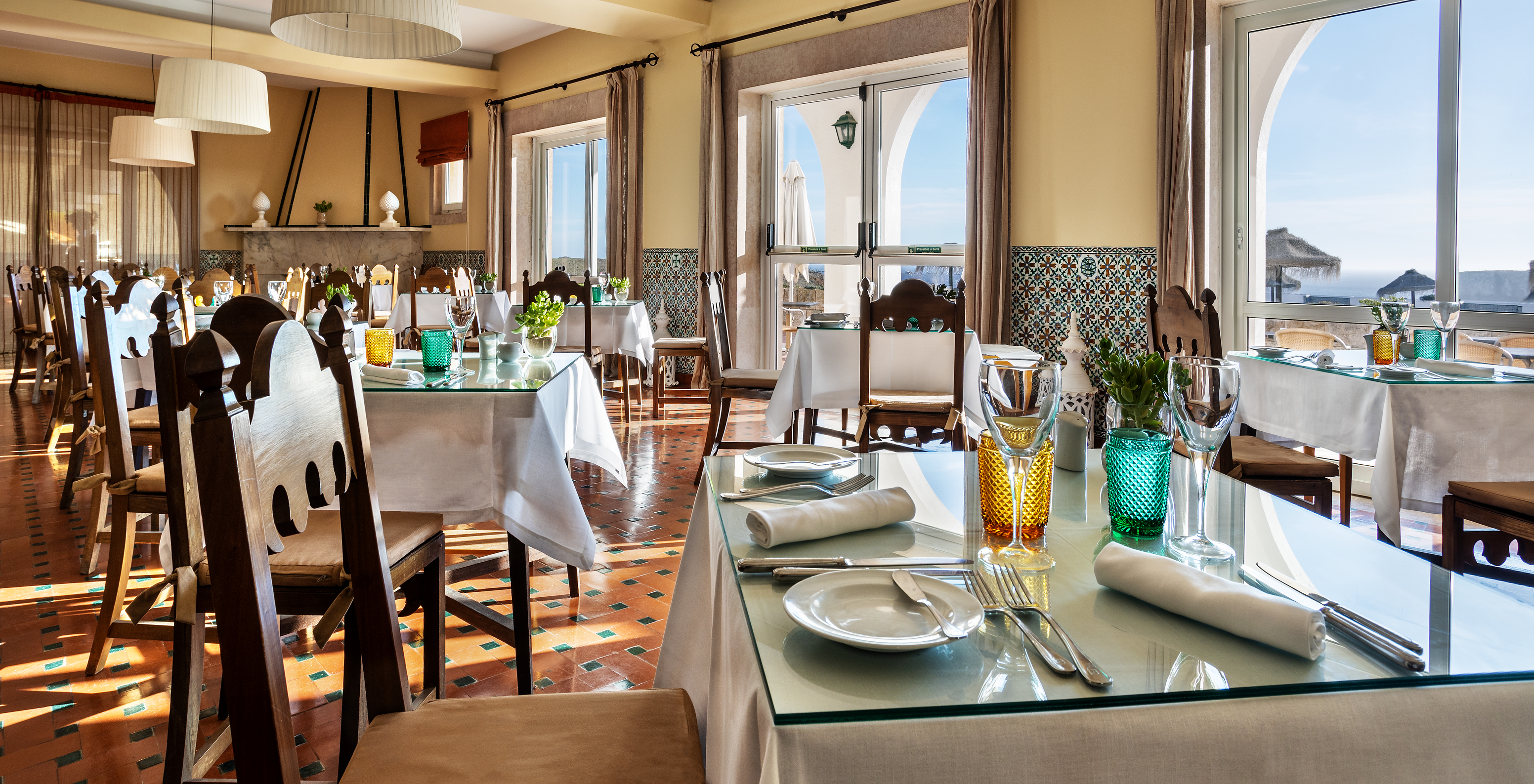 El restaurante Pousada Sagres, del Hotel Histórico en Sagres, tiene varias mesas y ventanas con vista al mar