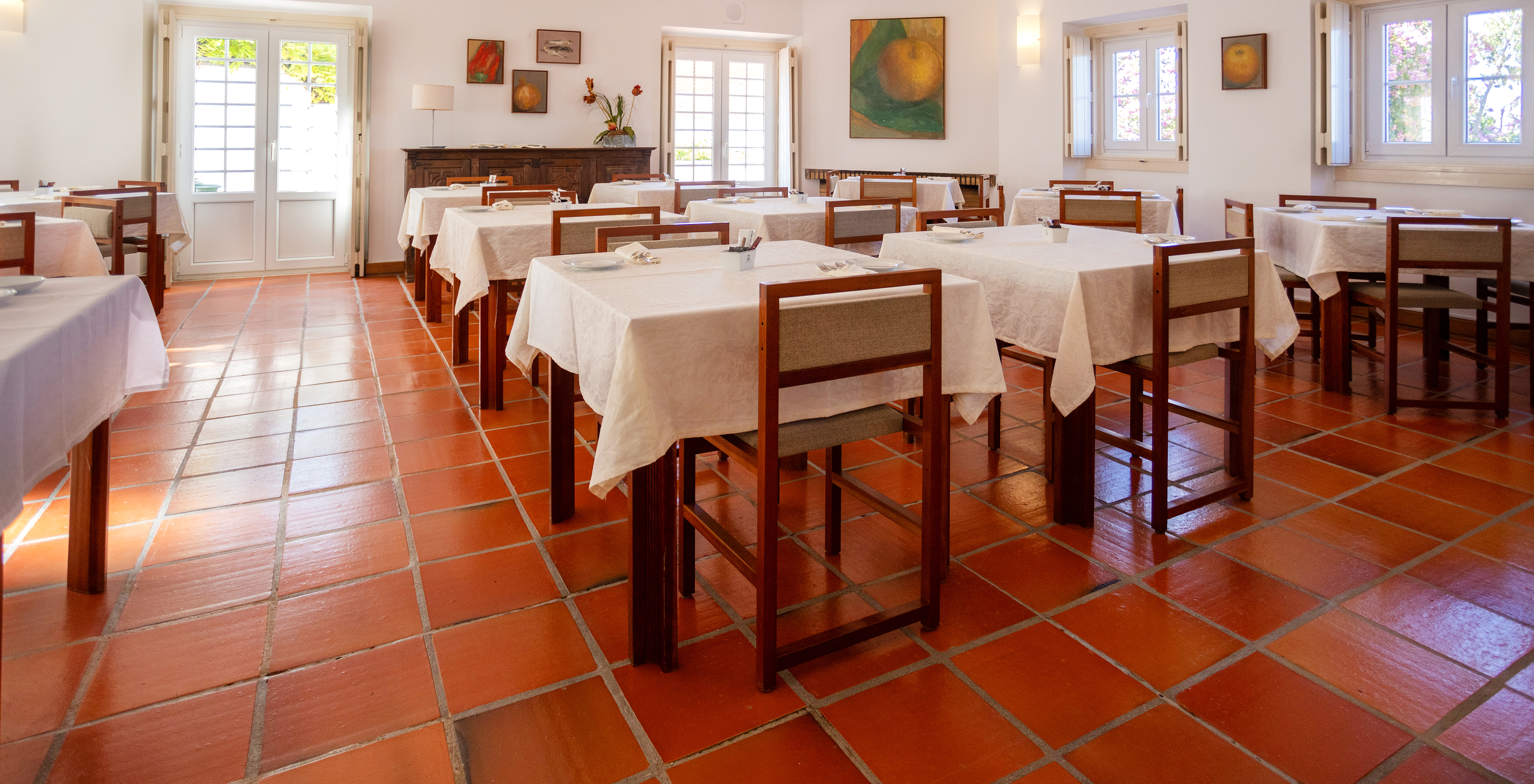 El restaurante del Hotel de Encanto en Ourém, tiene varias mesas preparadas para el desayuno y sillas