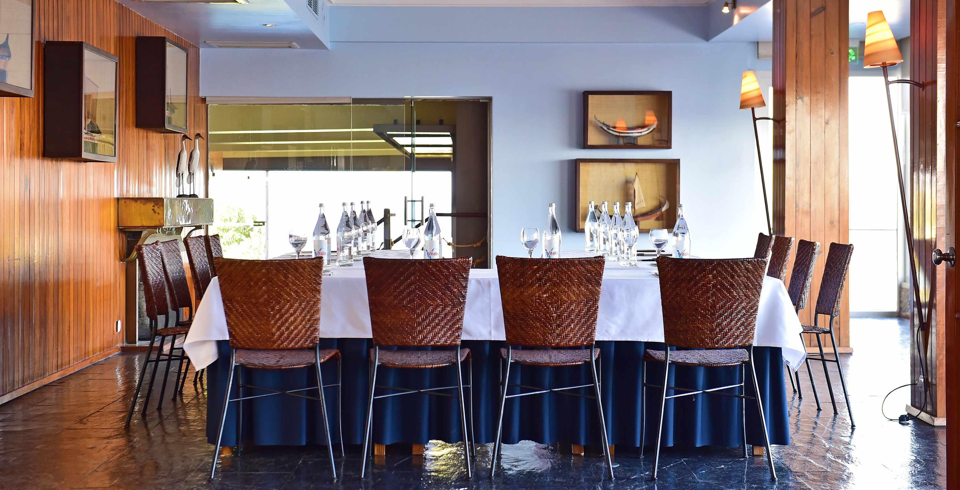 Sala de reuniones privada con varias sillas alrededor de una mesa con botellas de agua