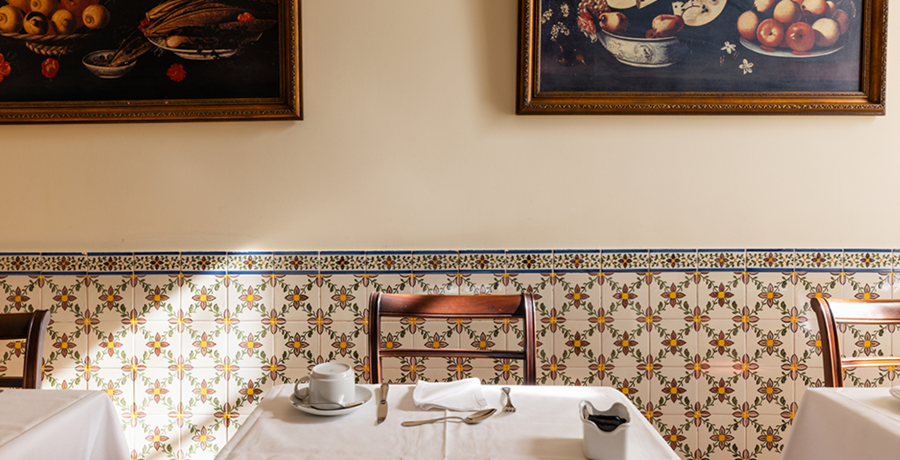 Zona de bar en un hotel histórico en Queluz, con una mesa y dos cuadros sobre la mesa