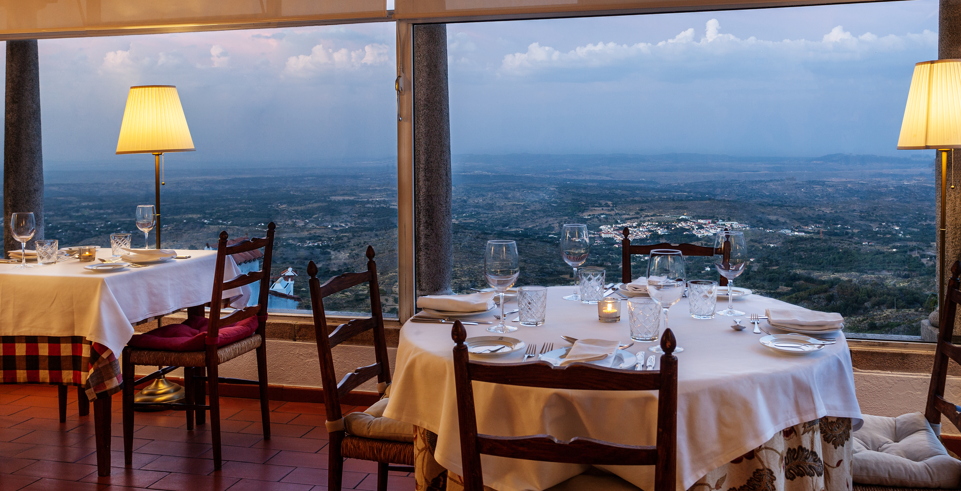 El restaurante Ninho D'Águias, del Hotel Histórico en Marvão, tiene varias mesas y ventanas grandes con vistas