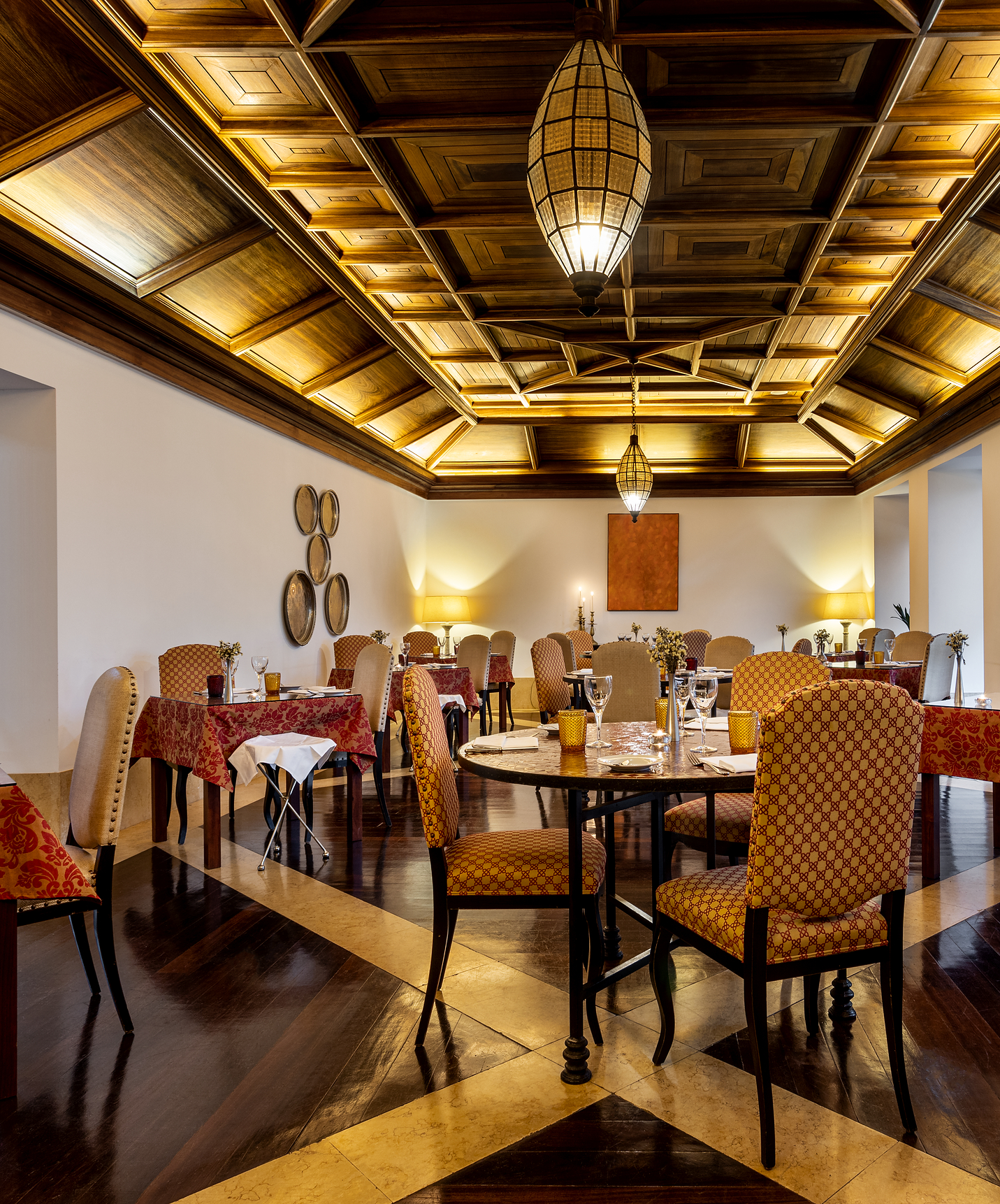 Varias mesas en el restaurante de Pousada Convento Tavira, con techo de madera trabajado