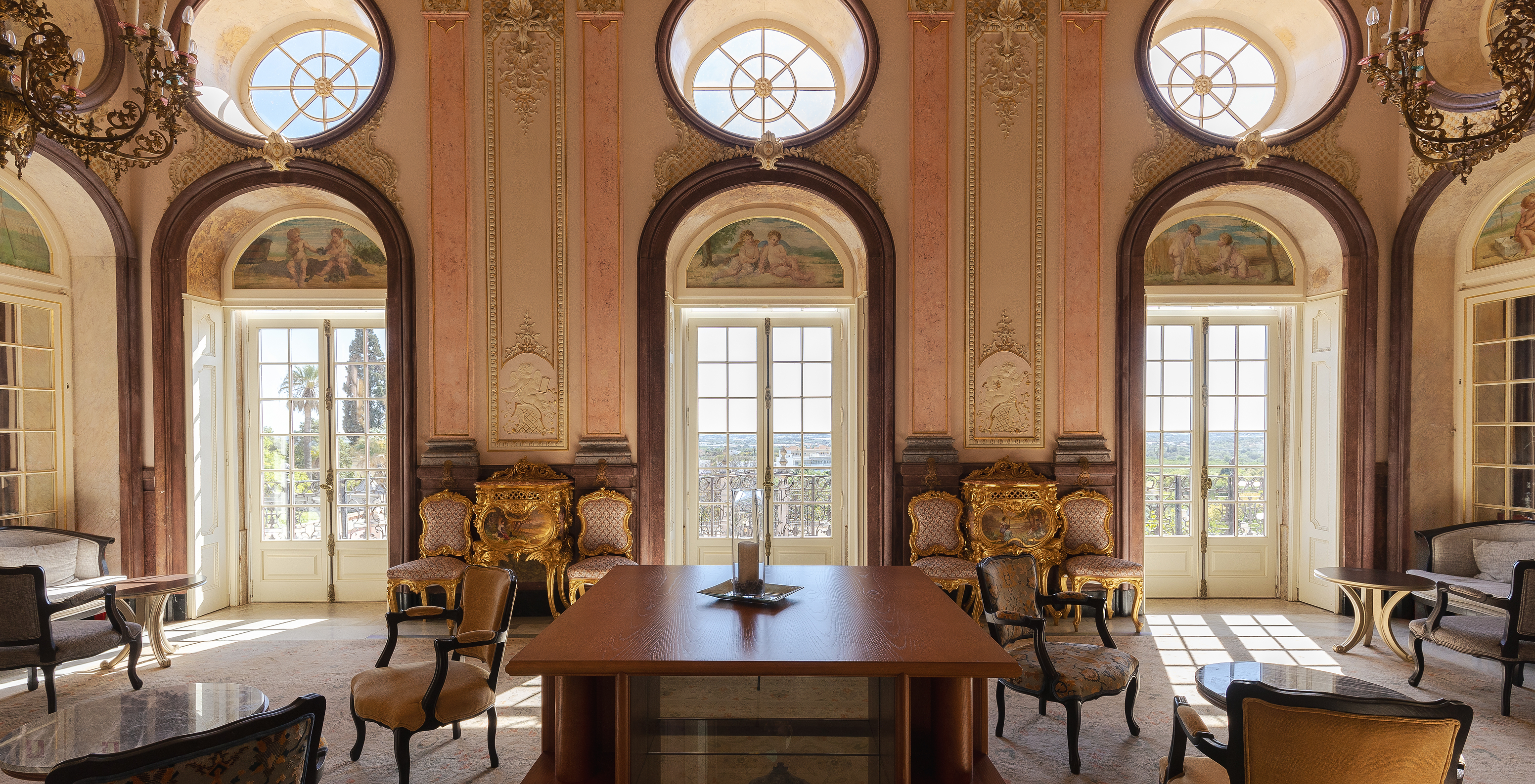 Sala histórica y lujosa, con tres grandes ventanas en la Pousada Palácio Estoi, hotel histórico en el Algarve